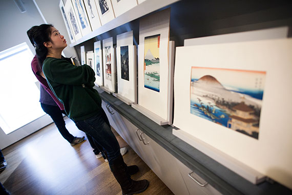 Cynthia Gu '19 examines  the collection of prints. 