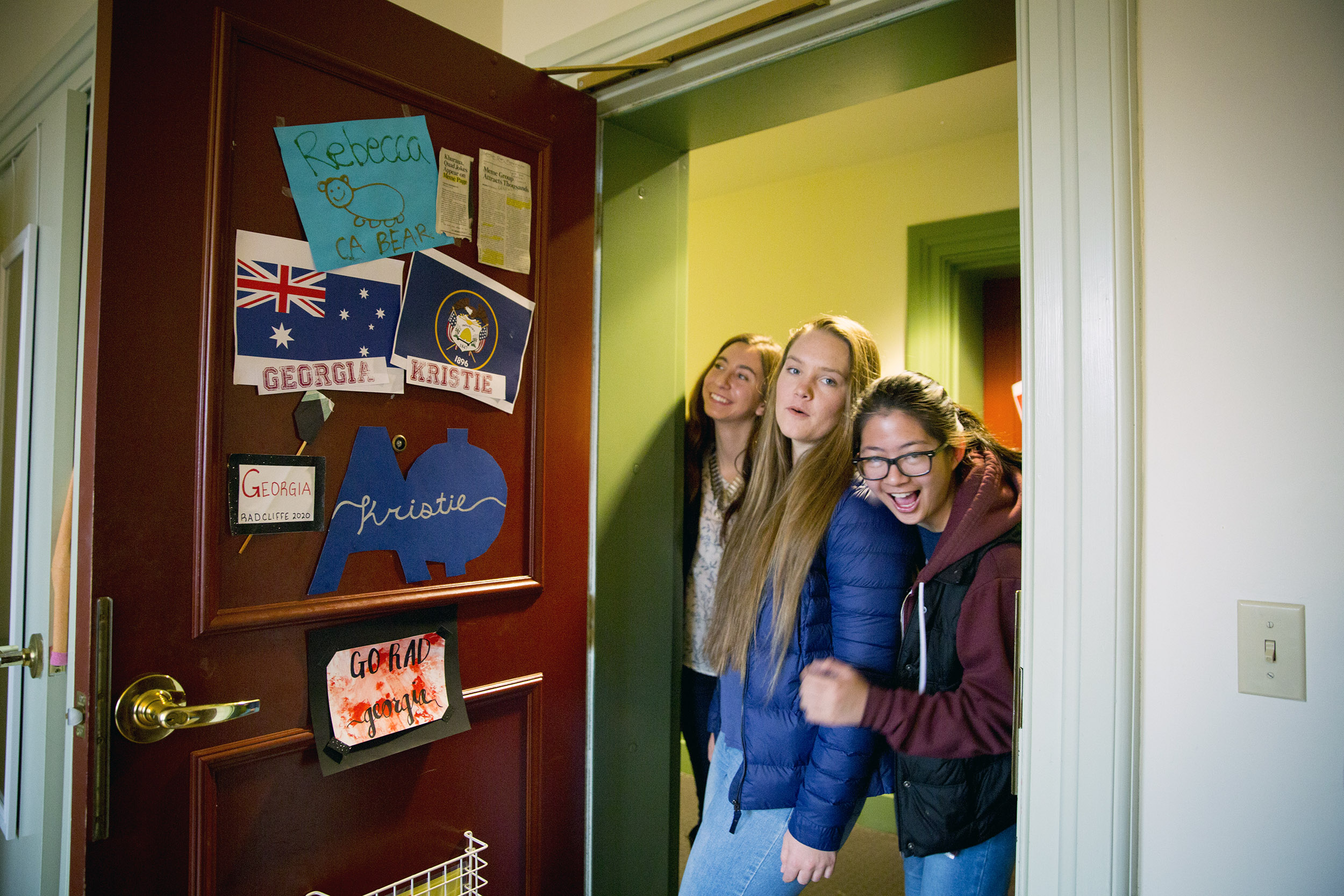 Roommates Kristie Colton (from left), Georgia Seidel, and Rebecca Chen peak inside their room in Thayer Hall.