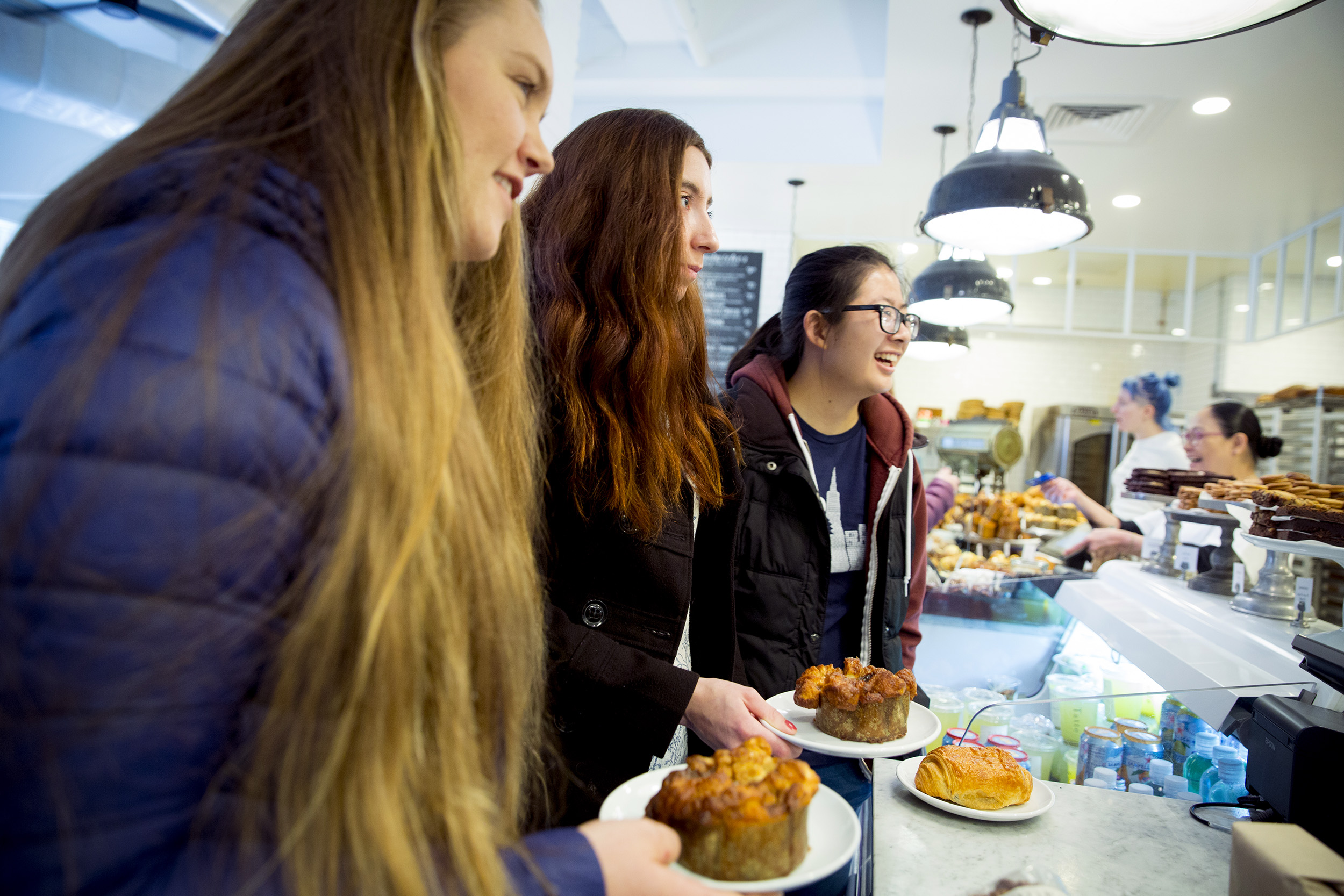 Thayer House freshmen friends, Georgia Seidel, '20 (from left) of Australia; Kristie Colton, '20 of Utah and Rebecca Chen, '20 of California in Tatte getting monkey bread and lattes.