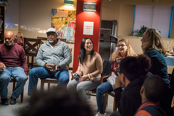 Priscilla Chan ’07 (center) reunited with residents of Franklin Hill in Dorchester, the community she volunteered as an undergraduate. Joining Chan on Sunday was Carmella Verrastro ’19 (sitting to Chan’s left), who is the current student director of Franklin Afterschool Enrichment.