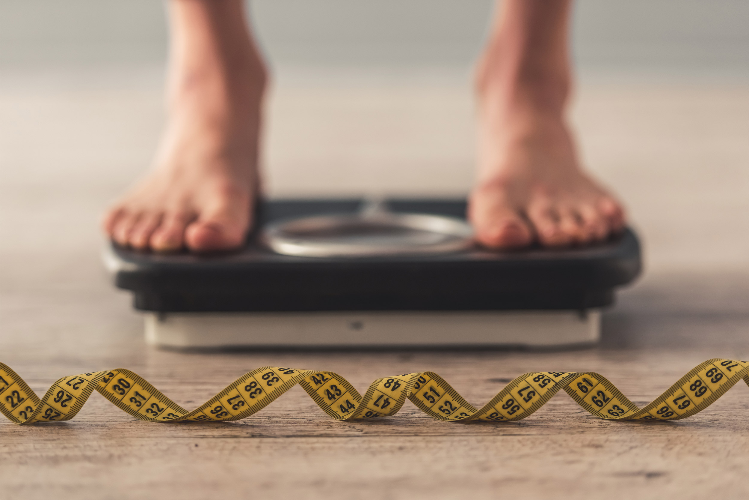 woman feet standing on weigh scales,