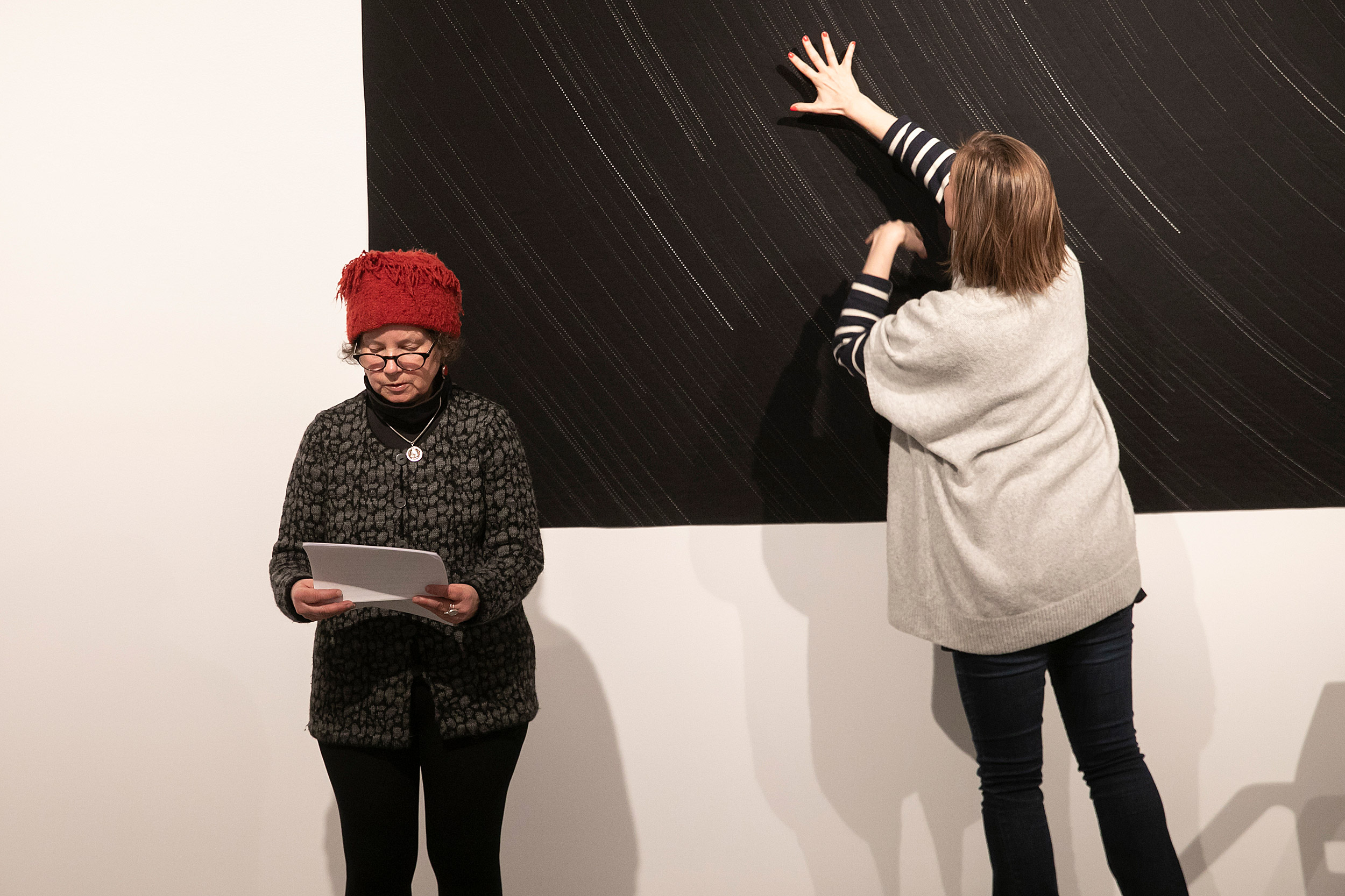 Annie Silverman reads as CÈcile GuÈdon traces star tracks on a quilt.