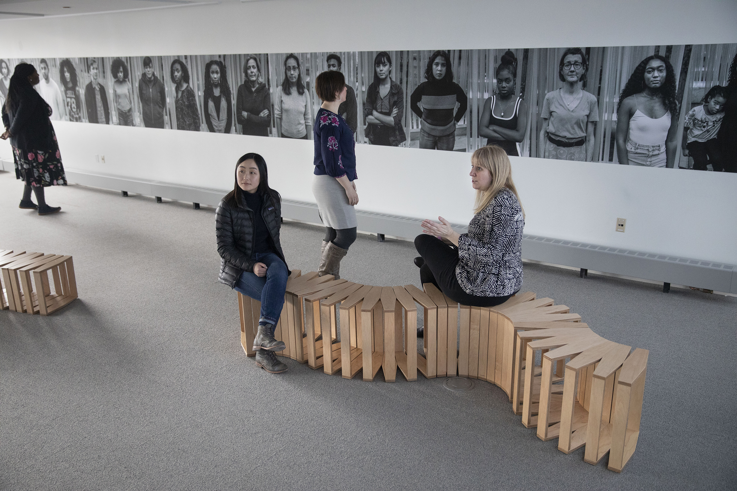 Viewers sit in the gallery.