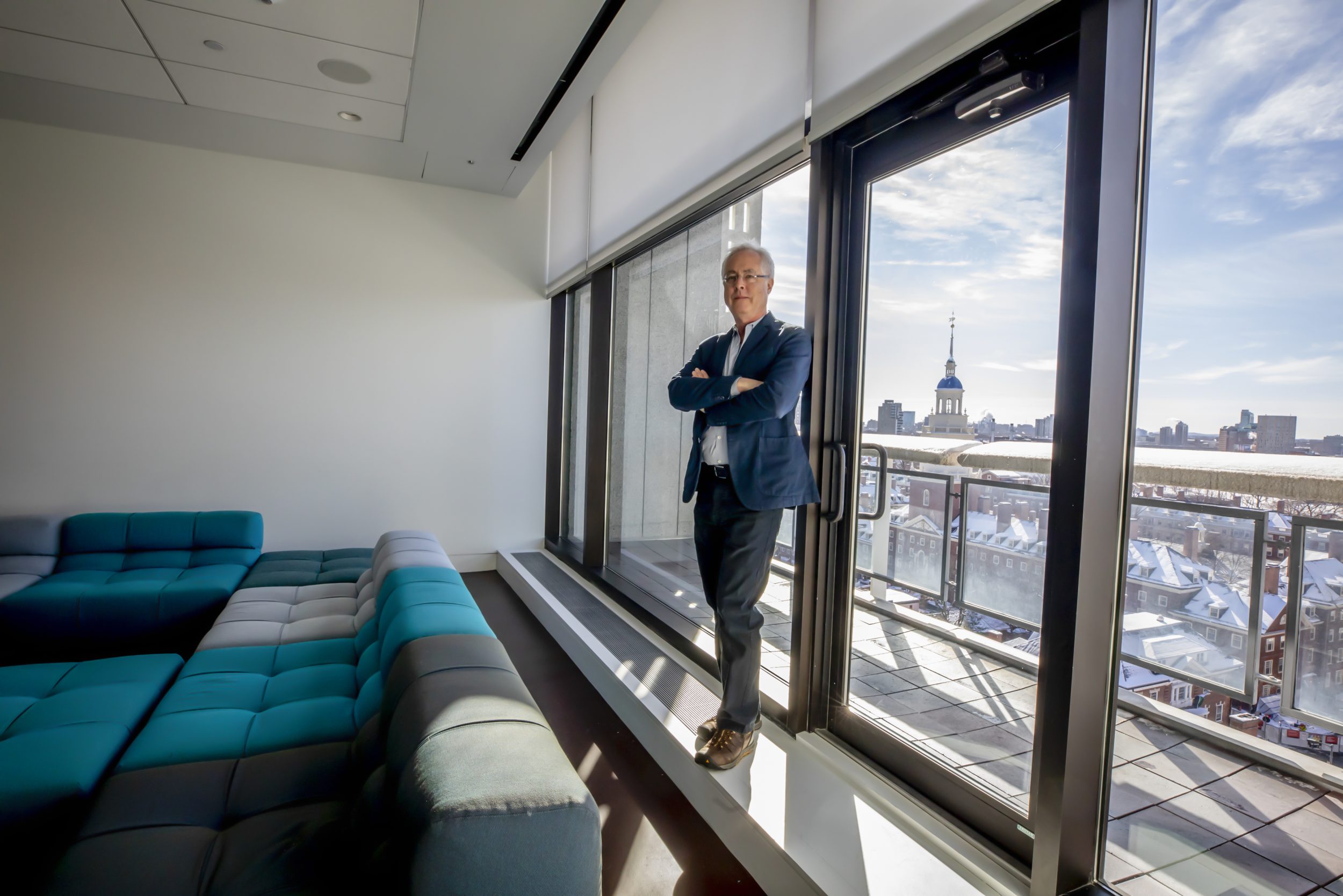 Menand standing in front of a window