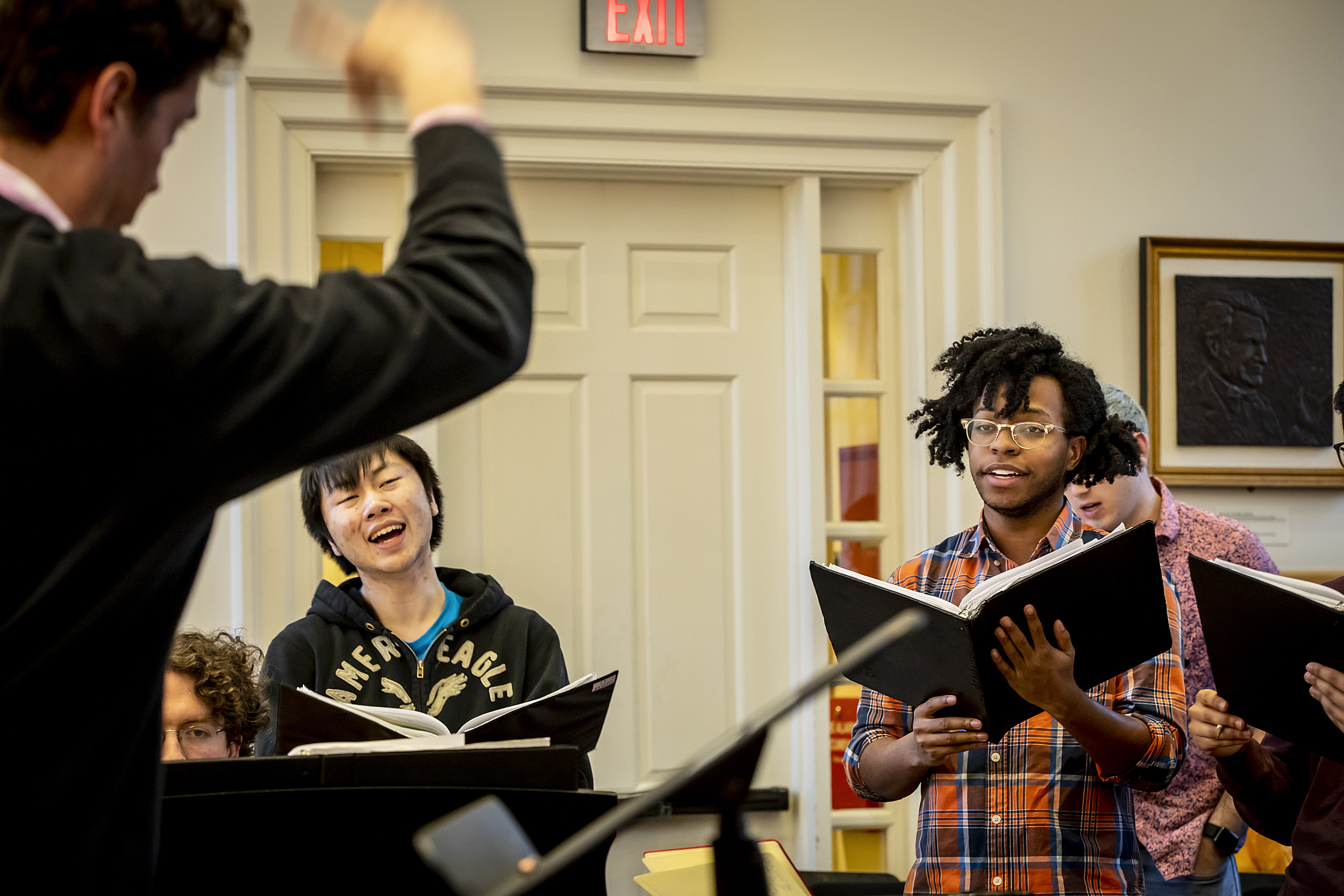 The Harvard Glee Club rehearses, led by Andrew Clark.