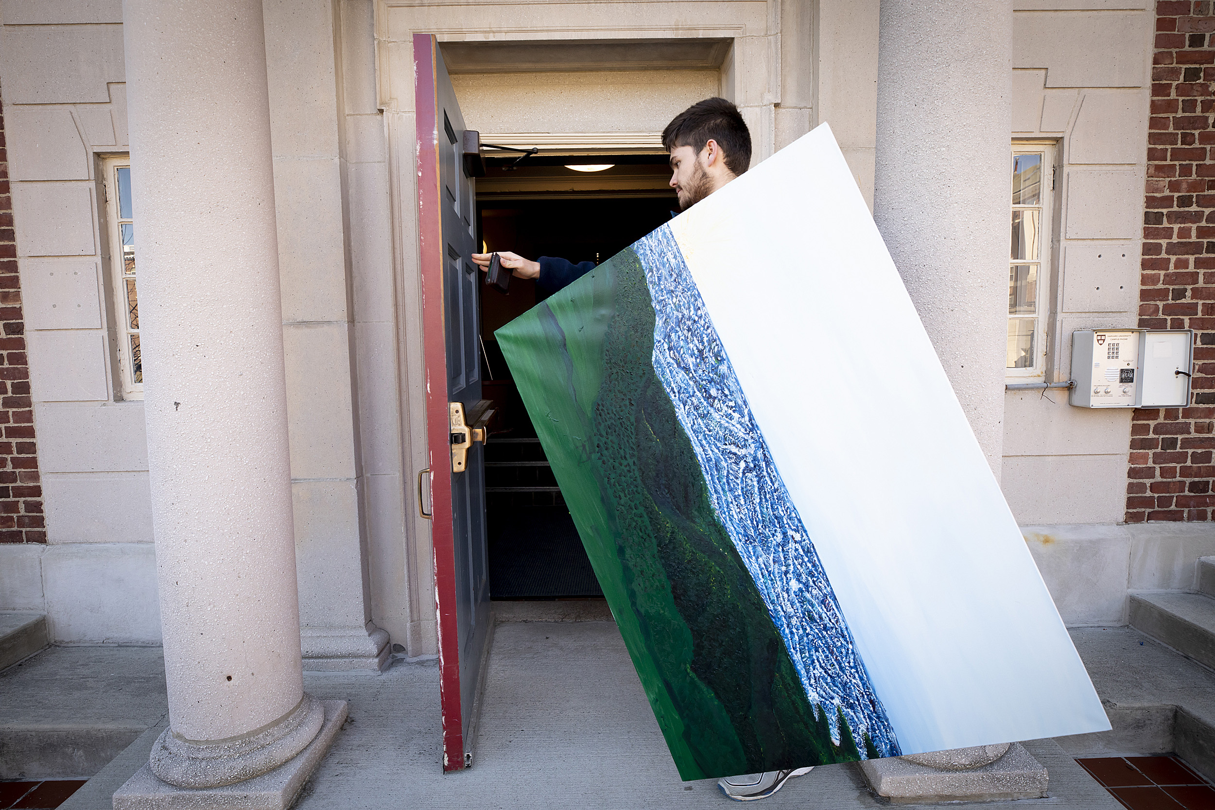 Rodrigo Cordova carries his painting.