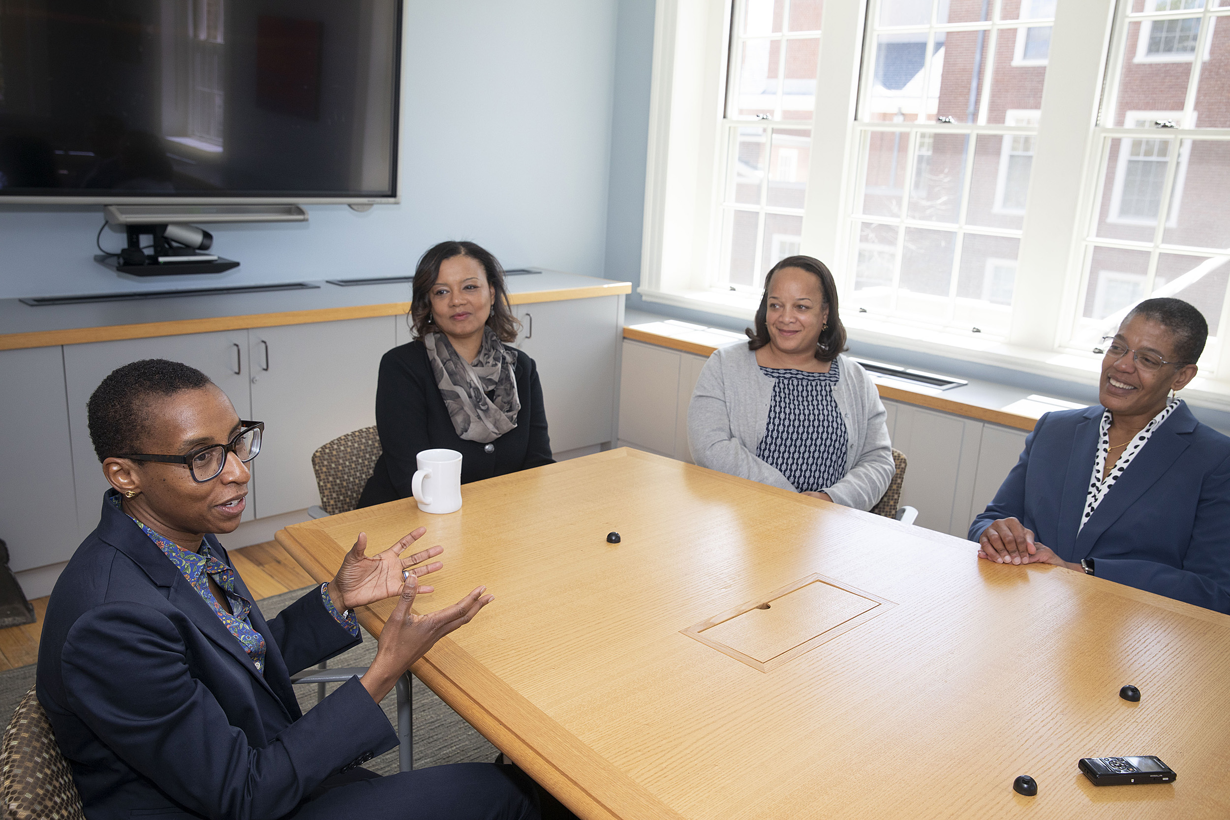 four women talking around a table