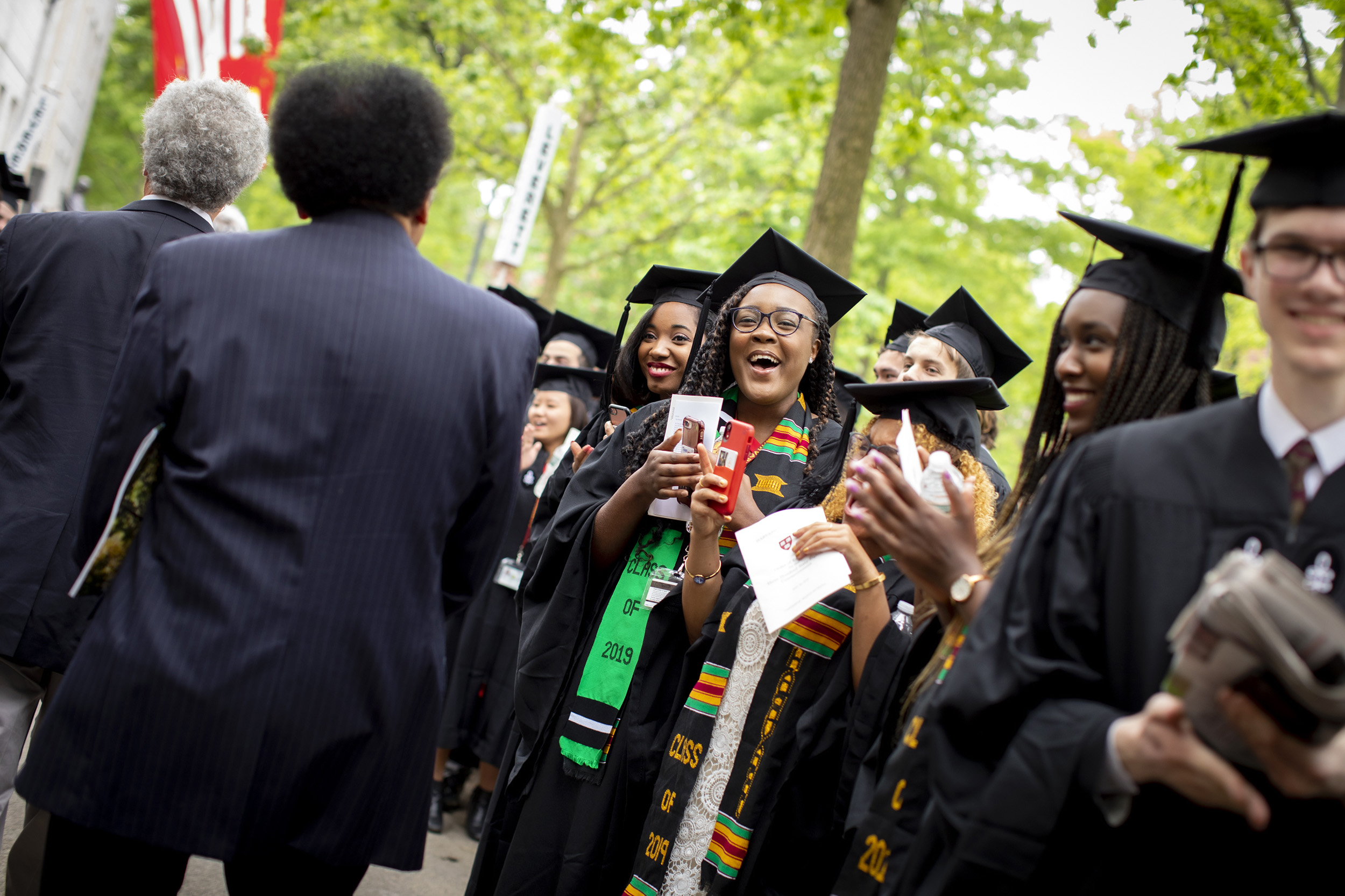 Old and new graduates cross paths during the alumni procession.