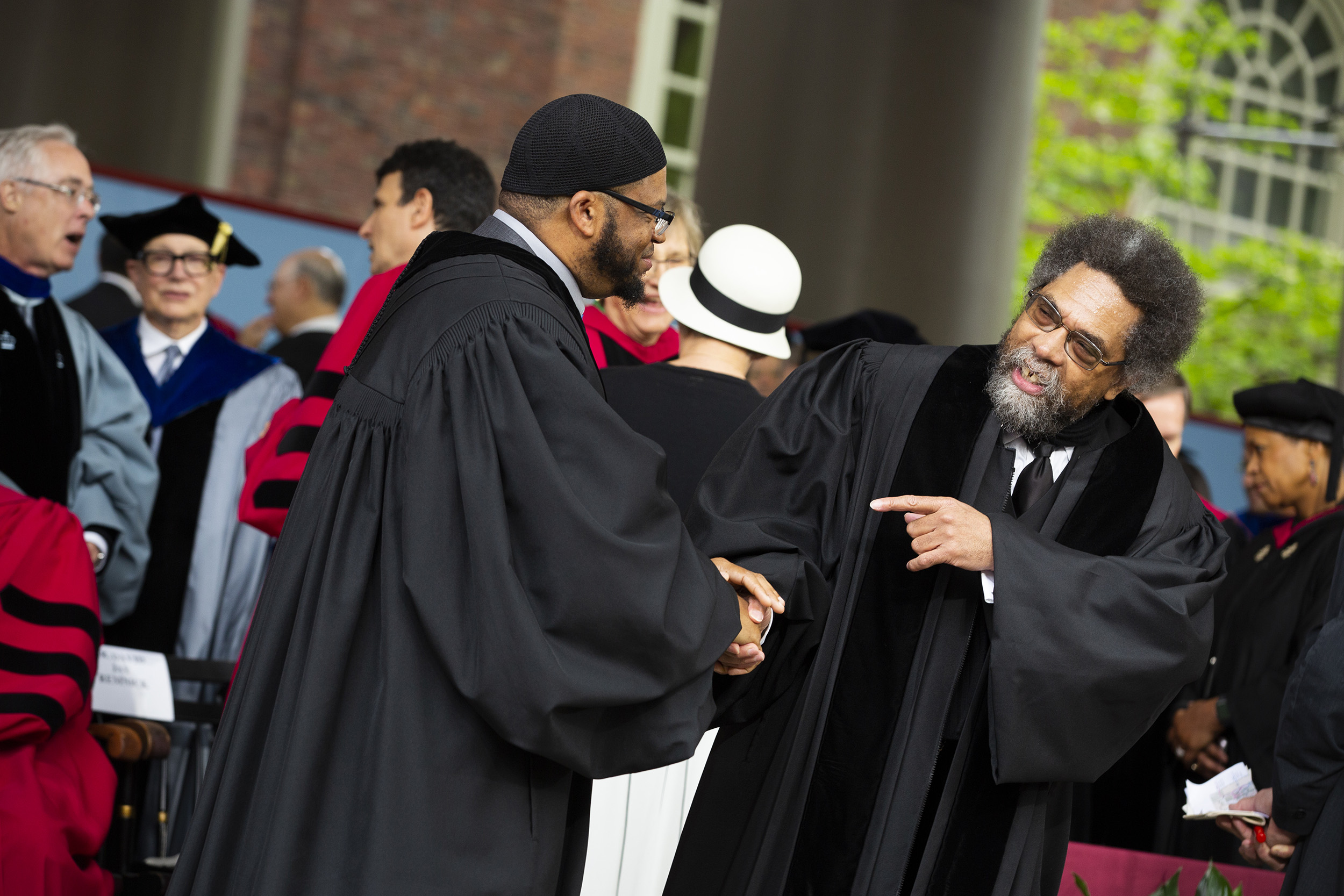 Khalil Abdur-Rashid and Cornel West shake hands on the stage.