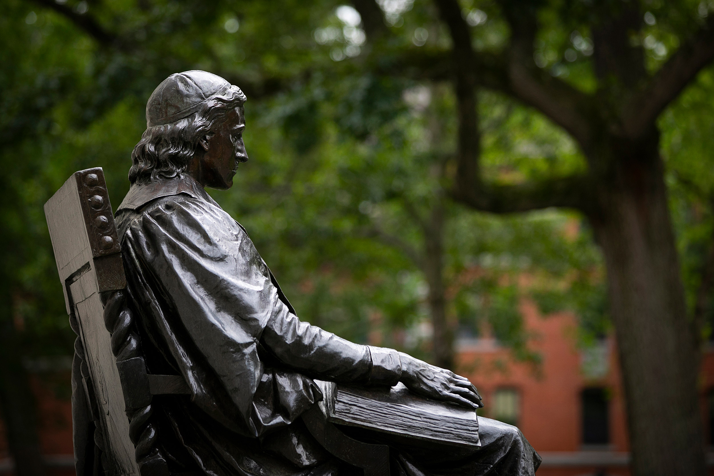 John Harvard statue with the Yard in the background.