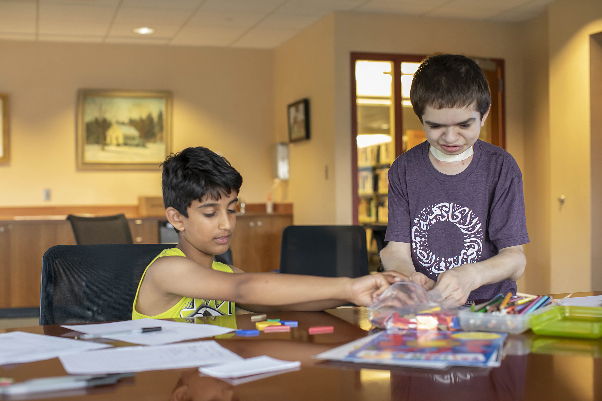 Ben Elwy works with an elementary school student at the library