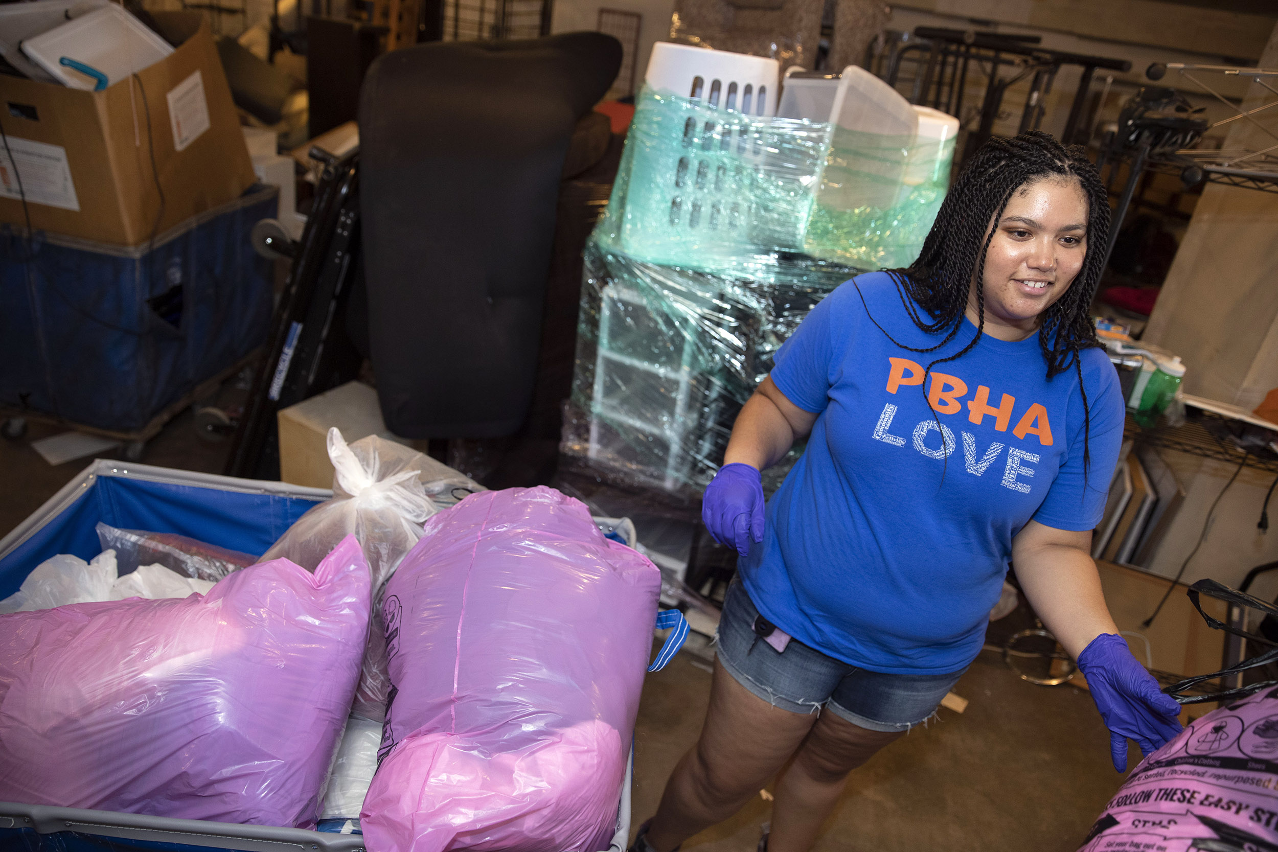 Student standing next to bags of donations