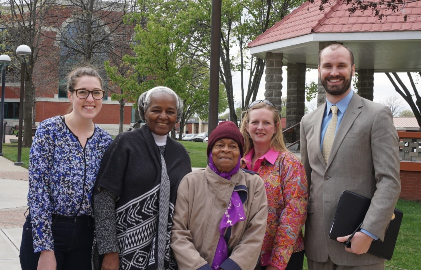 Benet and some of the people he helped in front of a court house