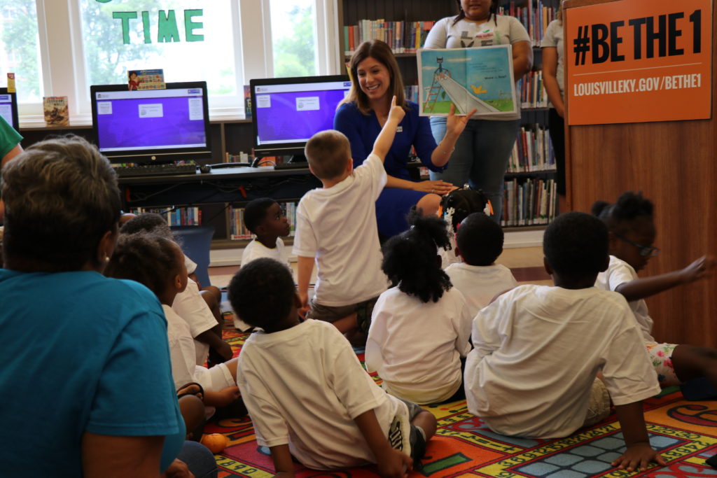 Theresa reading to a group of students