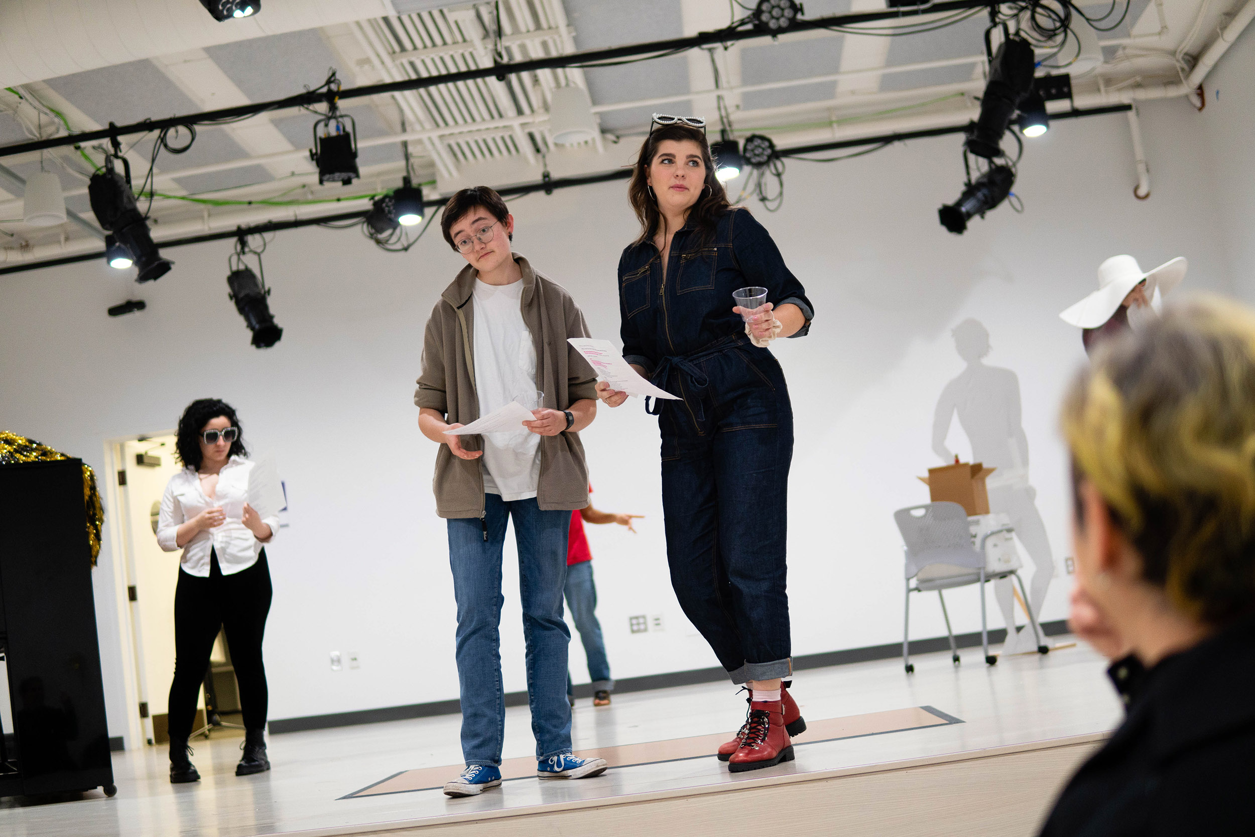 Amanda Gonzalez-Piloto, Isaac Heller, and Elle Shaheen rehearse on the stage.