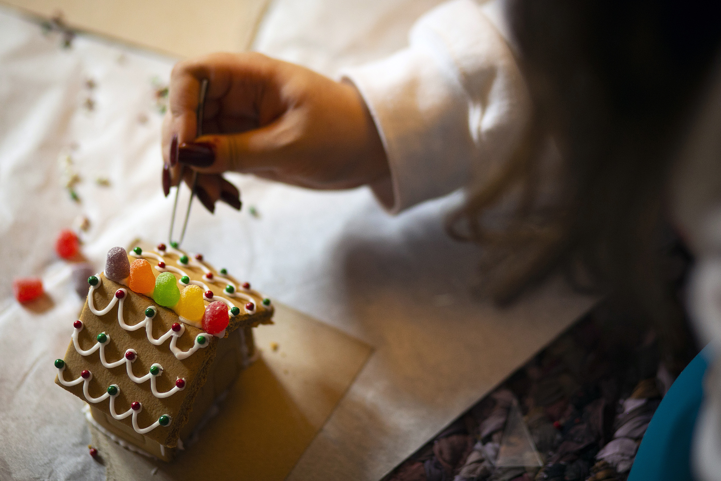 Final touches on a gingerbread house.