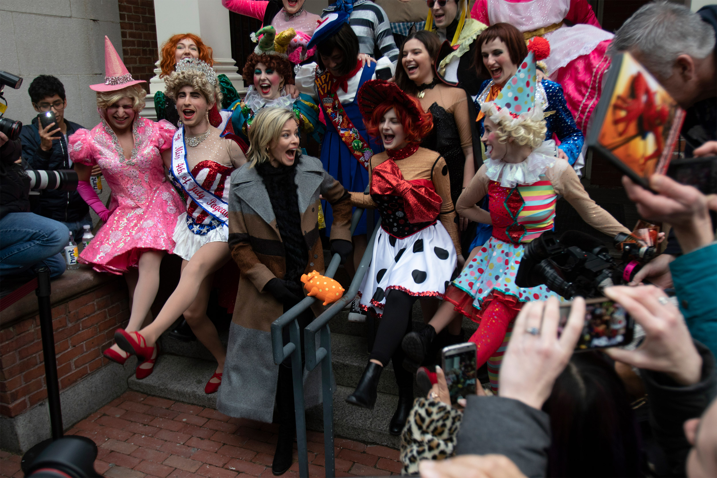 Hasty Pudding Woman of the Year Elizabeth Banks dancing on sidewalk.