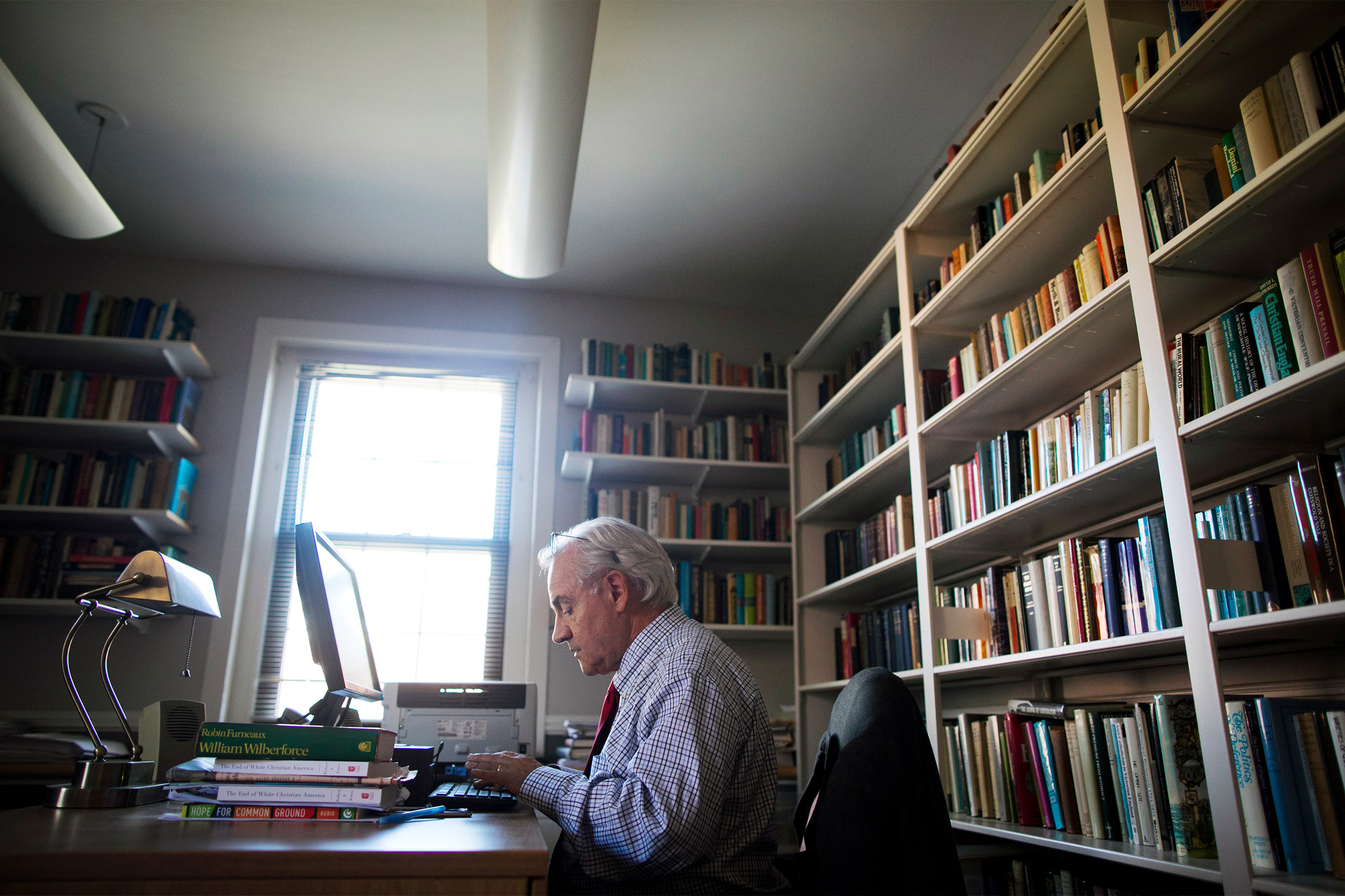 E.J. Dionne typing in his office.