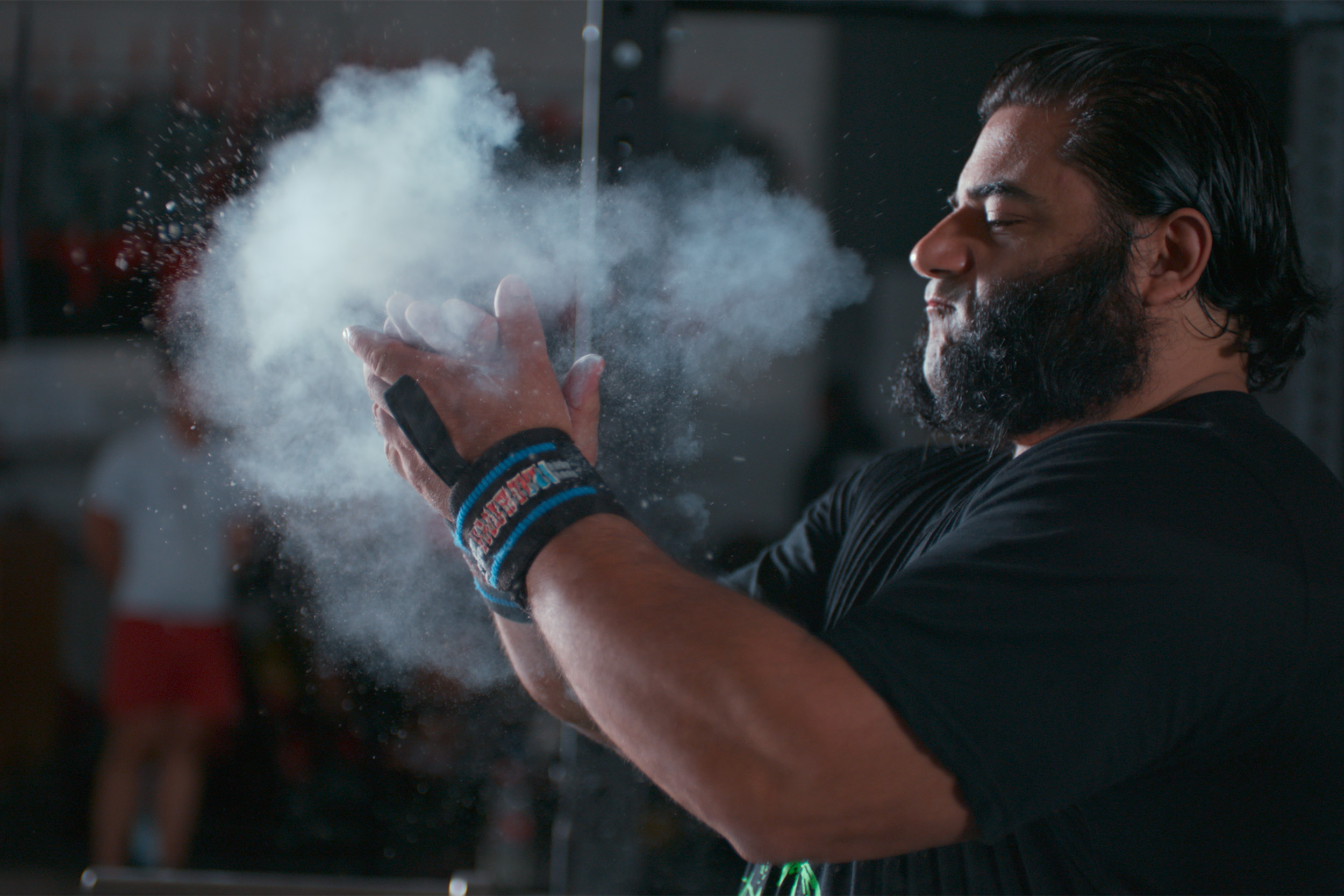 Patrik Baboumian brushing chalk off his hands.