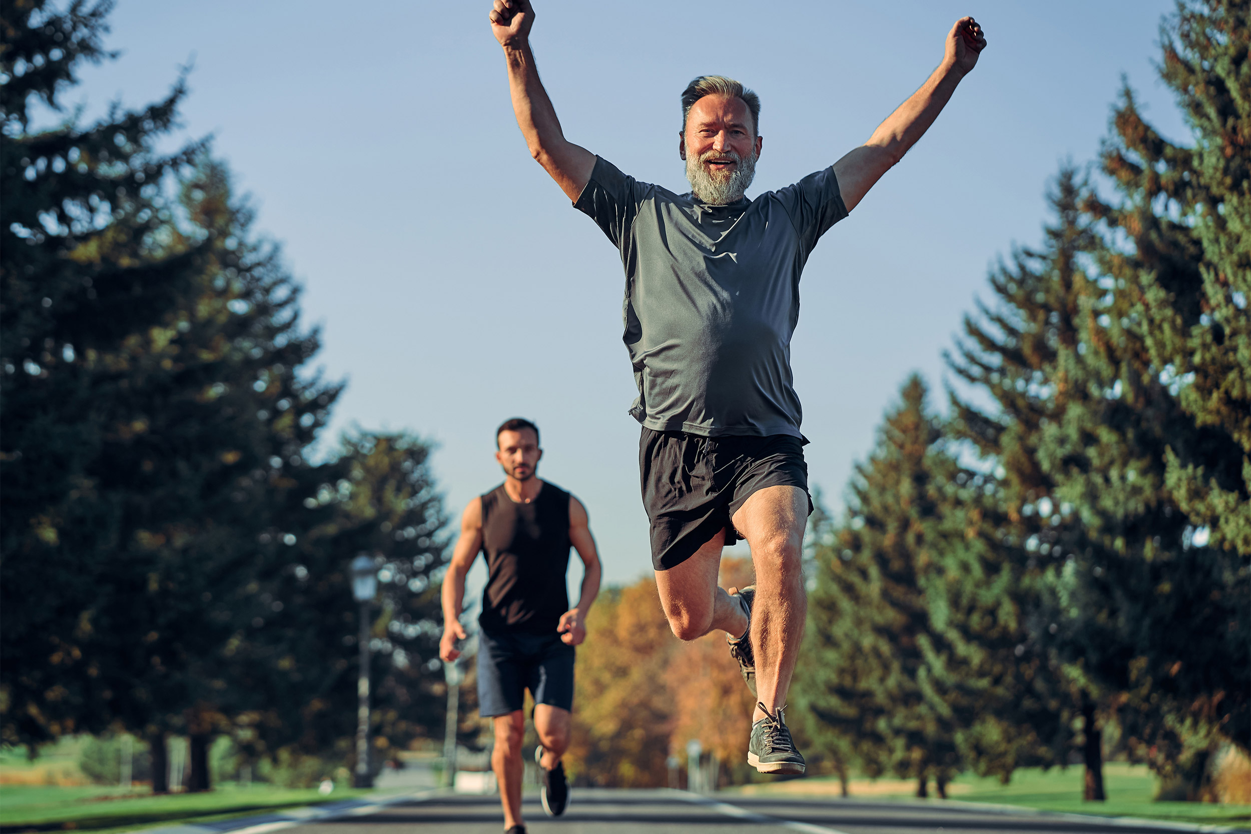 The old and young sportsmen running on the road.