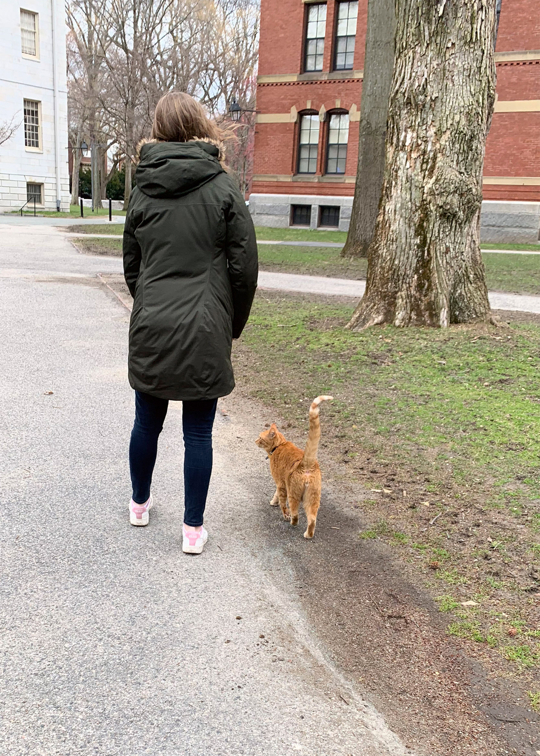 Student walking with Remy the cat.