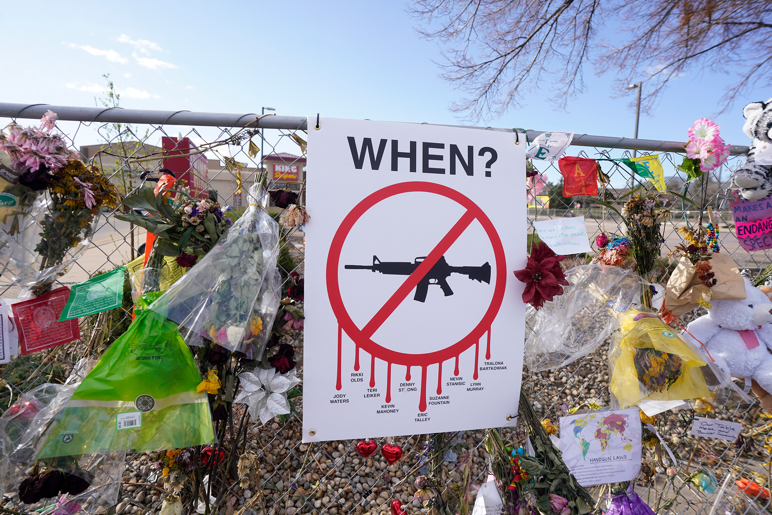 Tributes hang on the temporary fence surrounding the parking lot in front of a King Soopers grocery store.