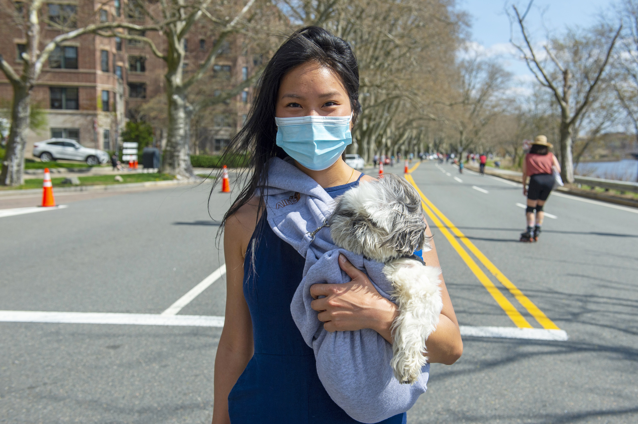 Joon You cuddles her shih tzu “Papi” as she walks along Memorial Drive.