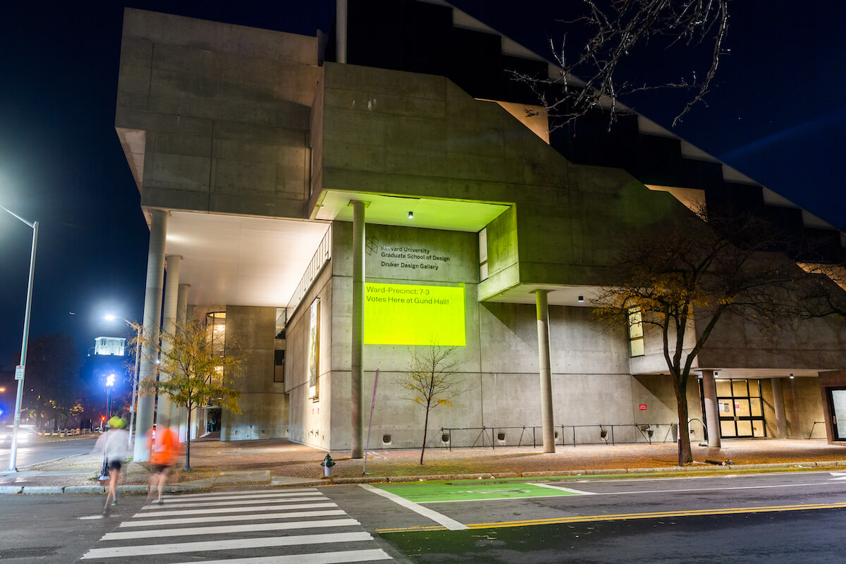 A projection on a building saying where people can vote.