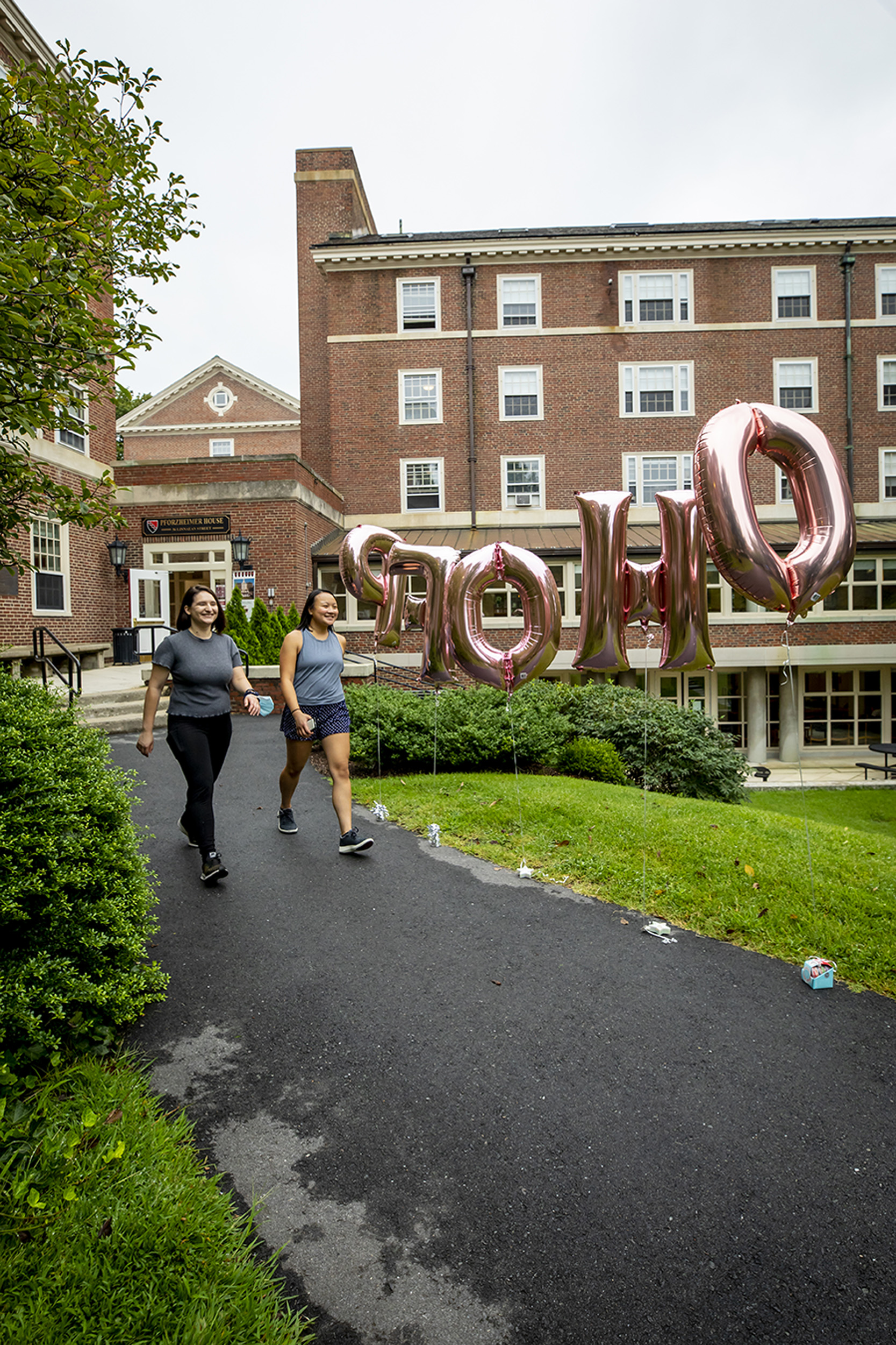 Lara van Rooyen '23, left and Allison Tu, '23 walk past the PfoHo welcome balloons.