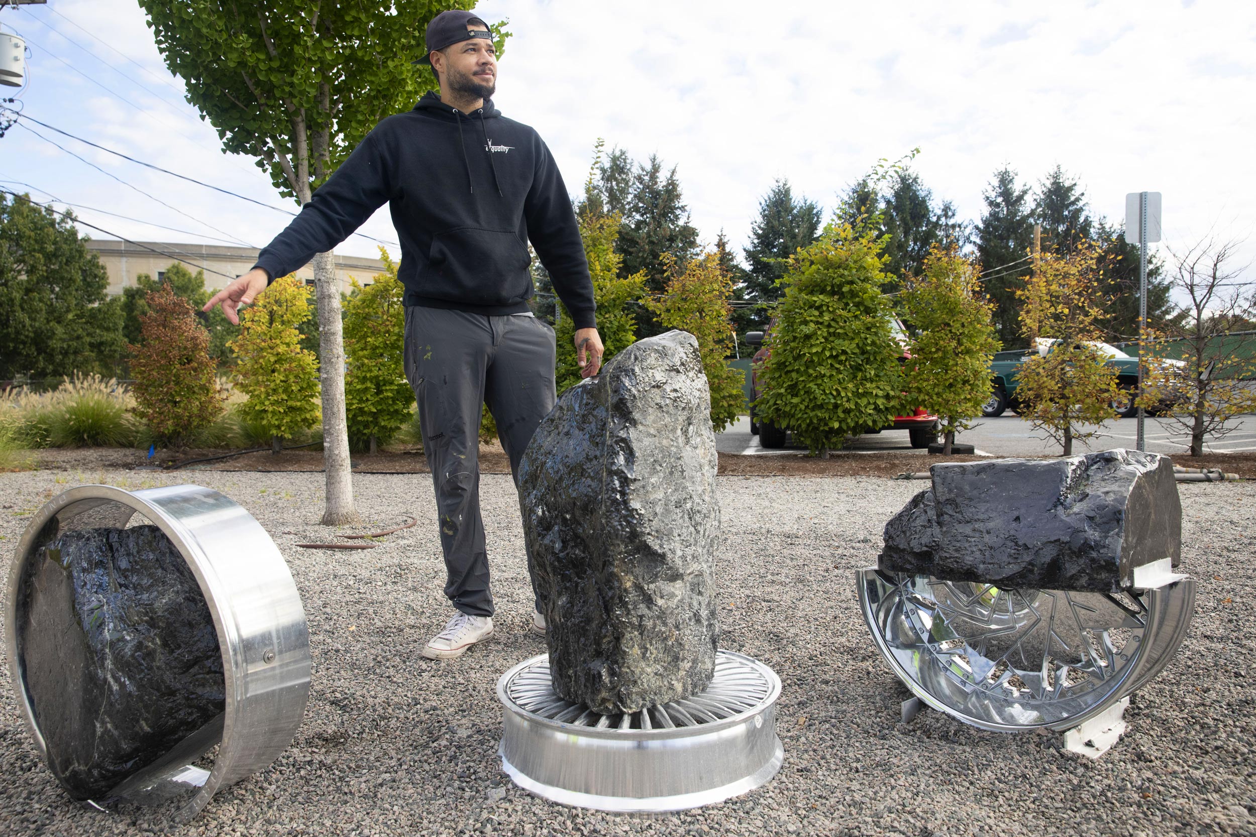 Jordan Weber, an HUCA artist, is pictured by his installation.