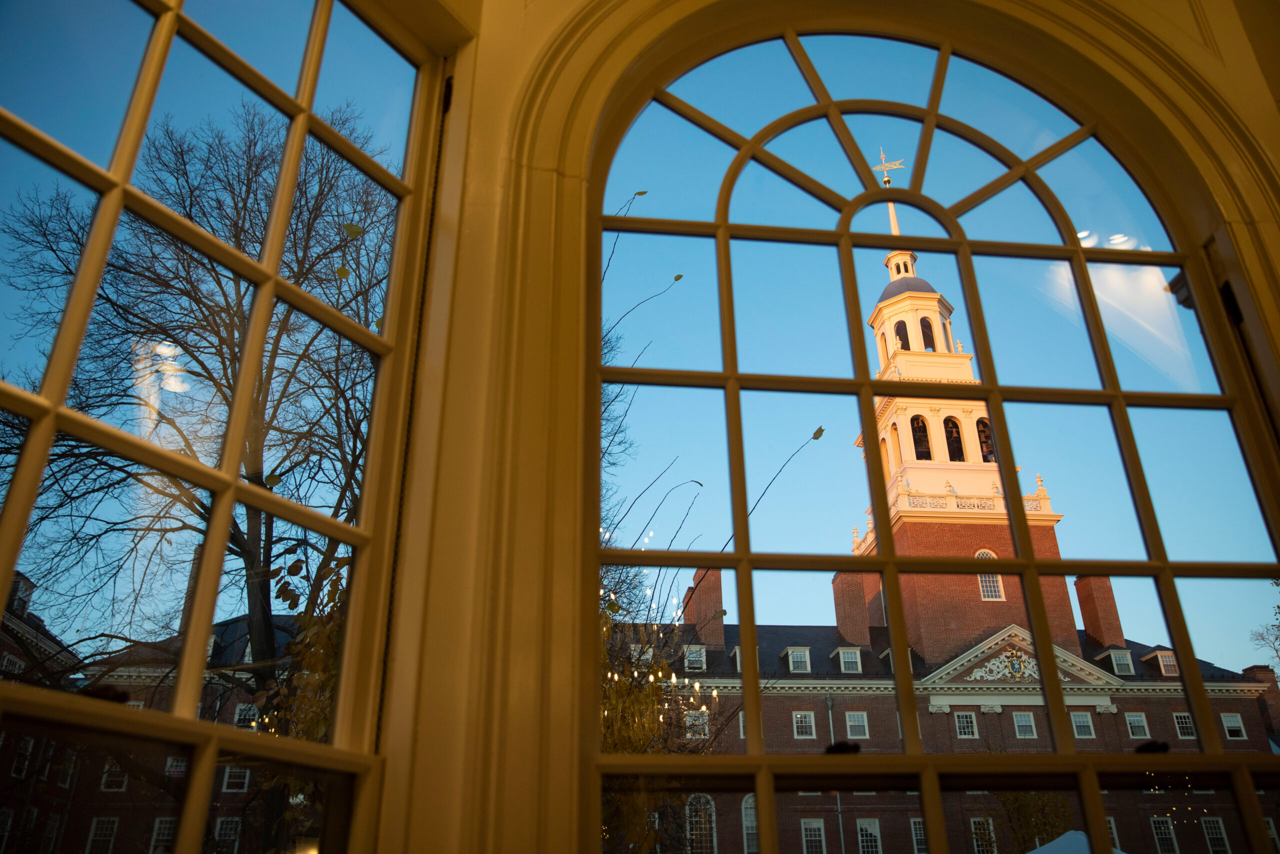 The sunset's warms light shines on the tower of Lowell House.