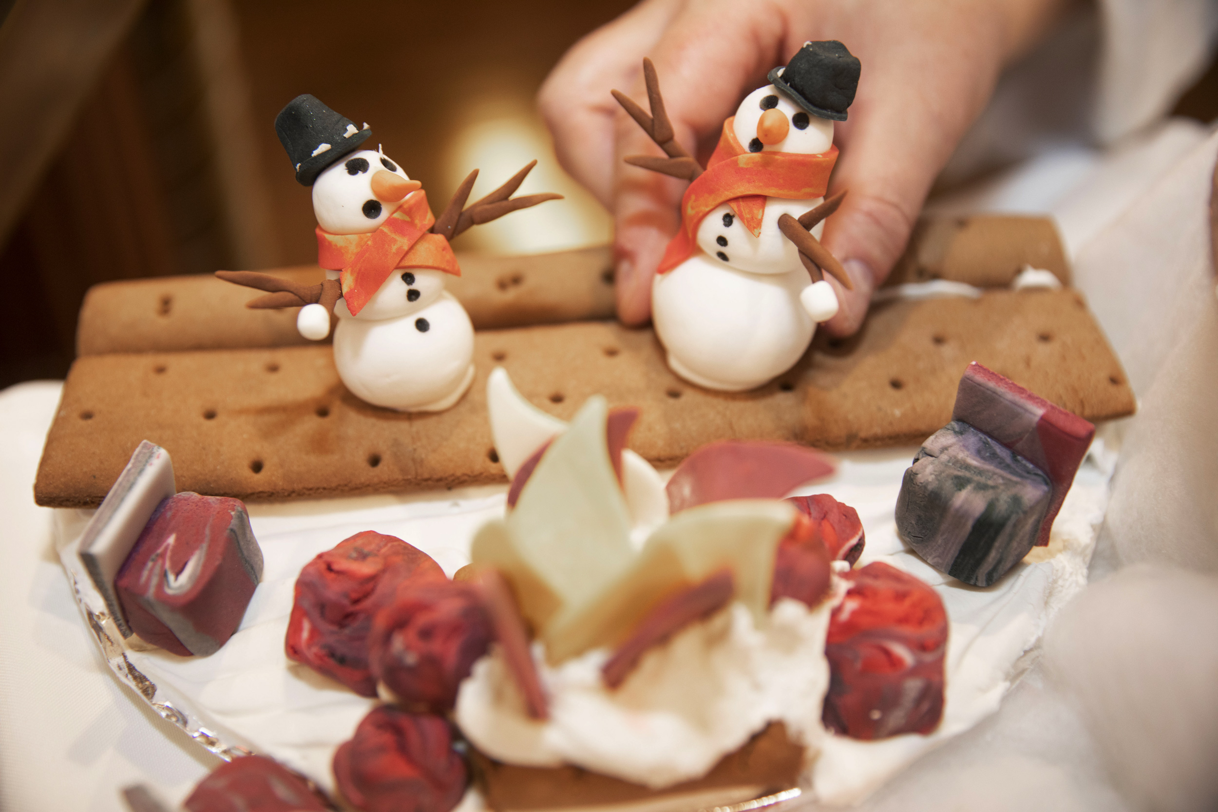 Snowmen sit on a bench in the gingerbread village displayed at the Harvard Faculty Club.