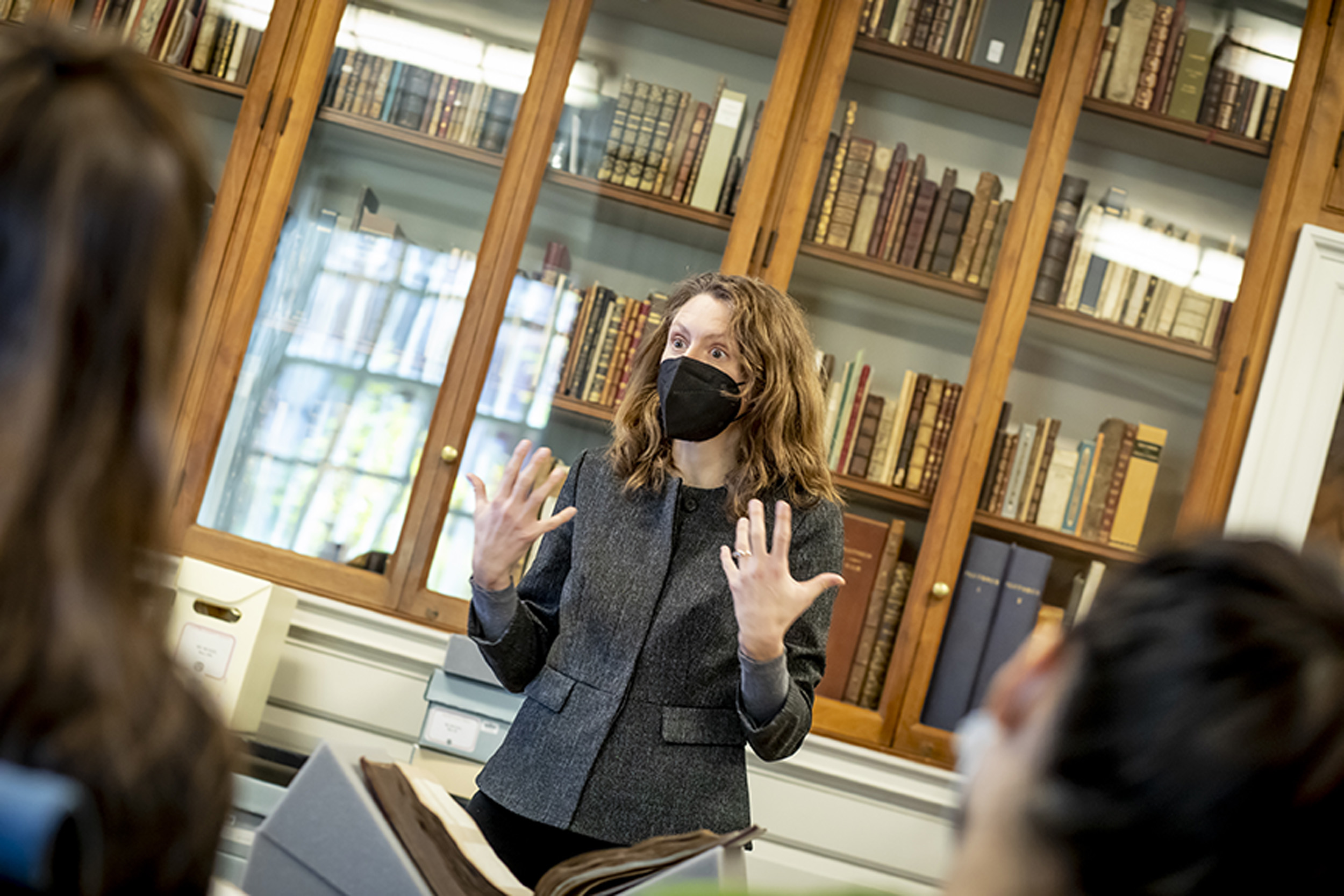 Irene Peirano Garrison leads class in front of Houghton bookcase.