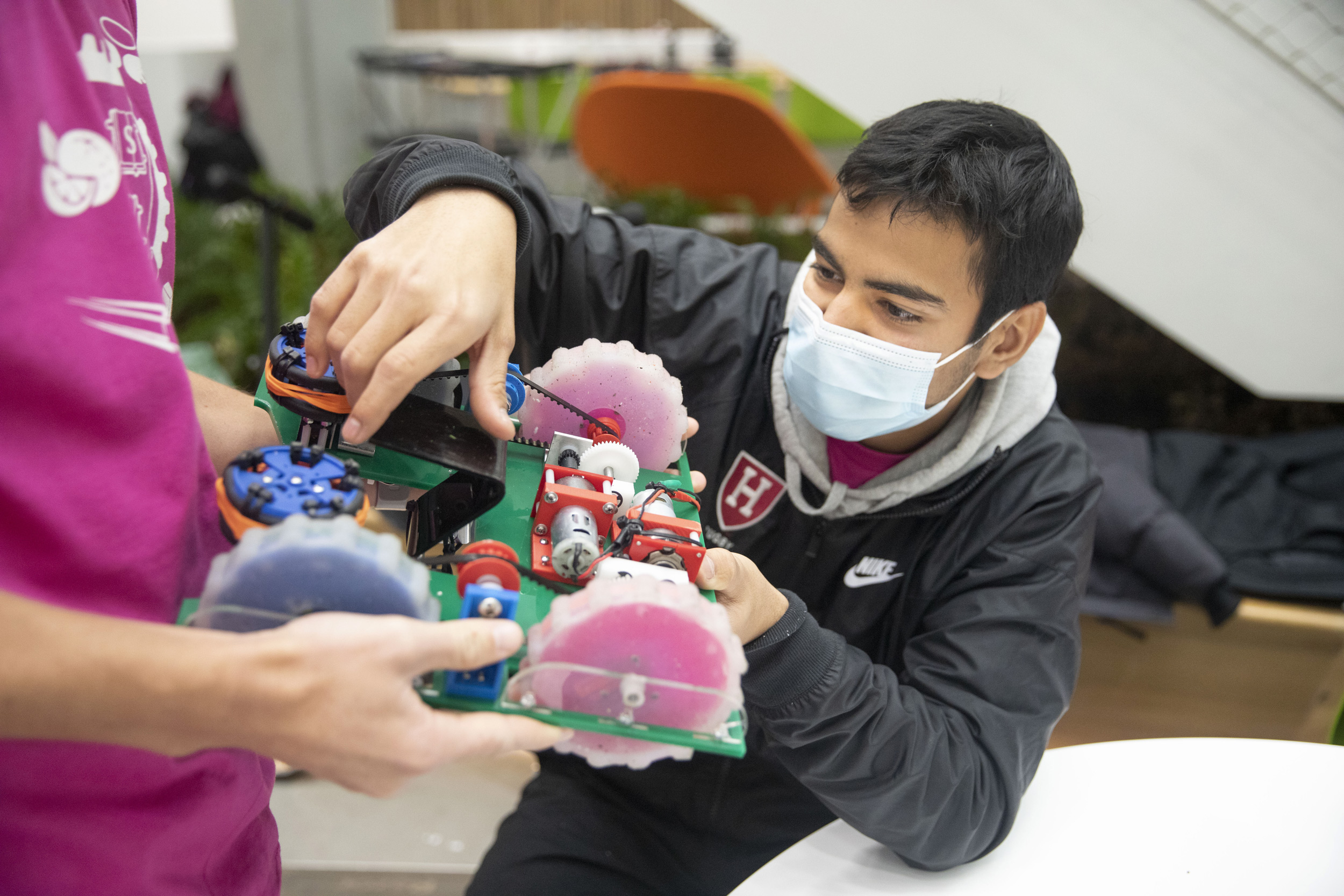 Rohan Jakhete ’24 (right) and Alex Bell ’25 (hands shown) make a pit stop during Turf Wars.