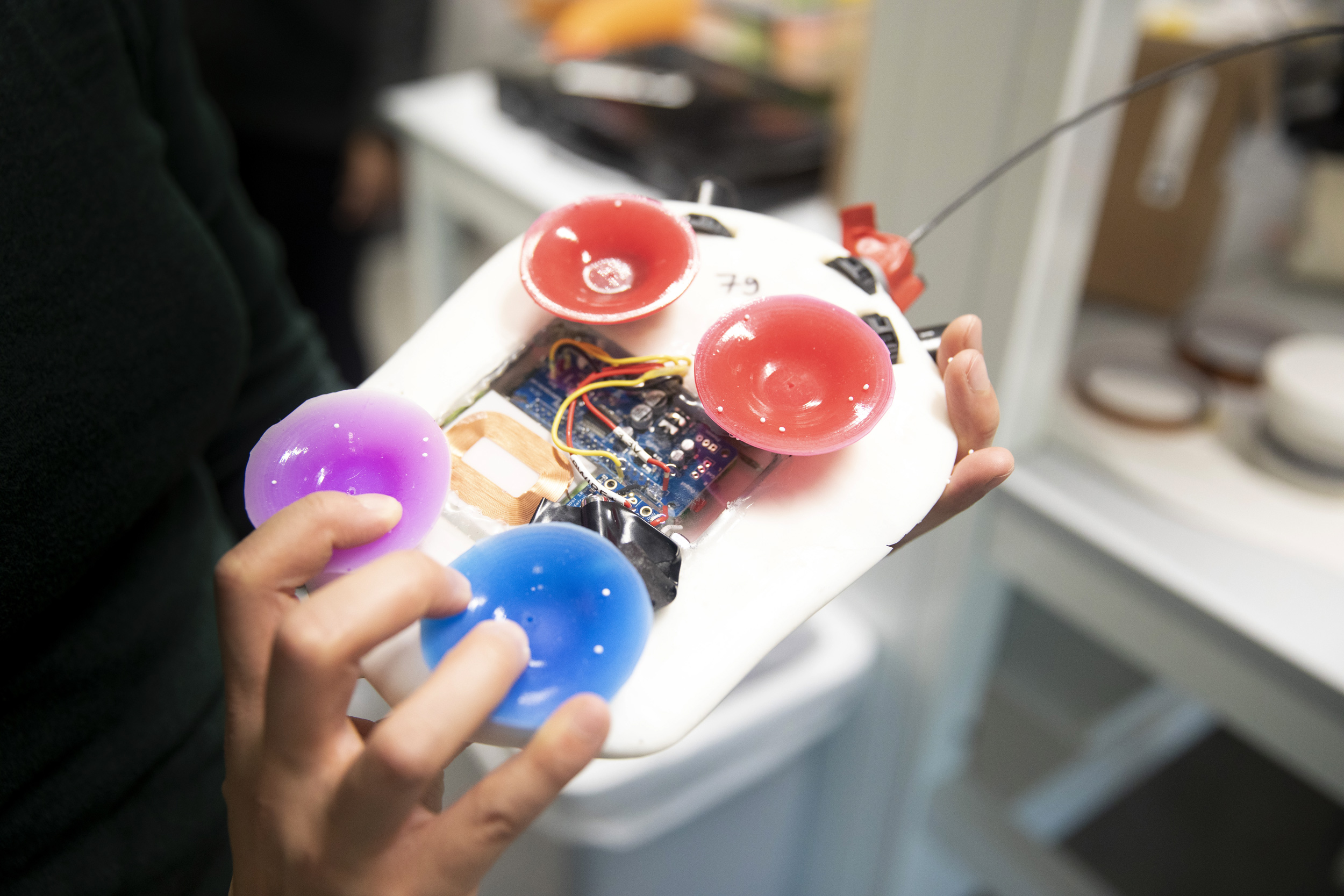 Emma Steinhardt (hands shown) works in the Microrobotics Laboratory to improve the design of the microrobot known as the Harvard Ambulatory Microrobot (HAMR).