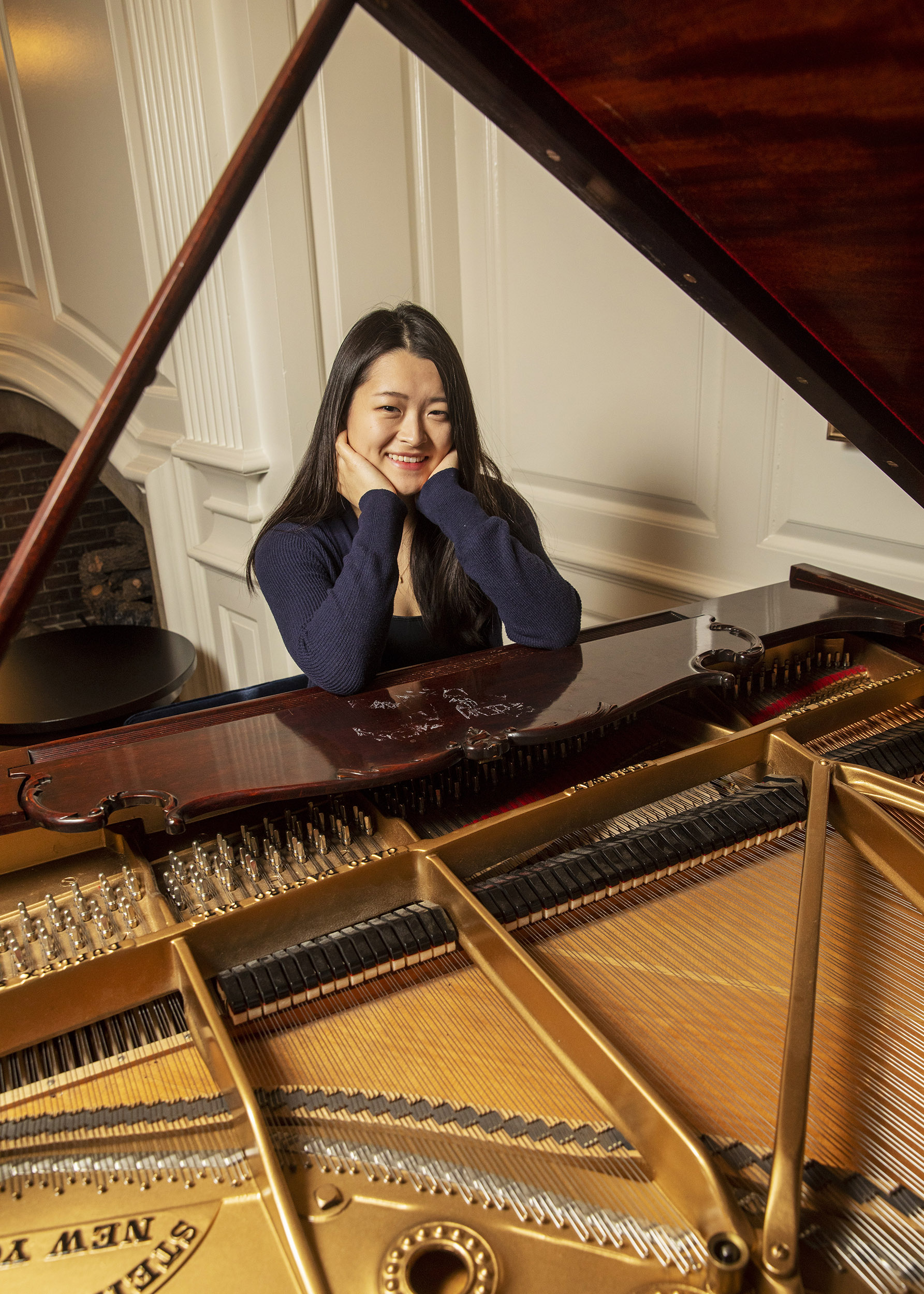 Julia Riew sits at piano.