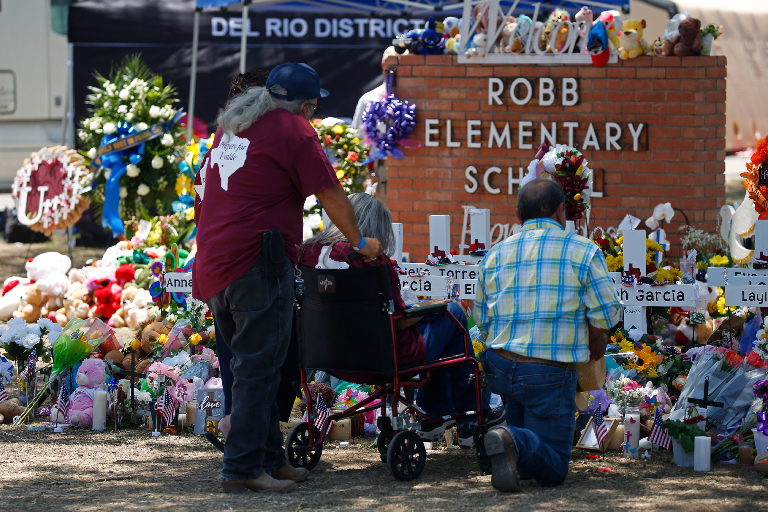 People pay their respects at a memorial outside Robb Elementary School