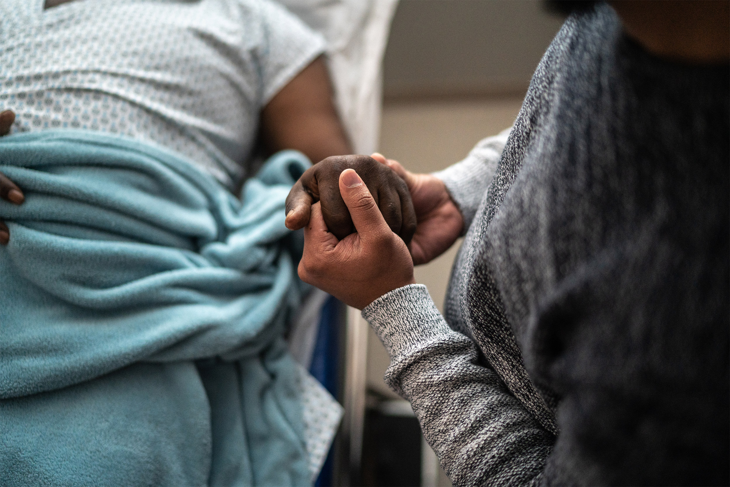 Man holding patient's hand.