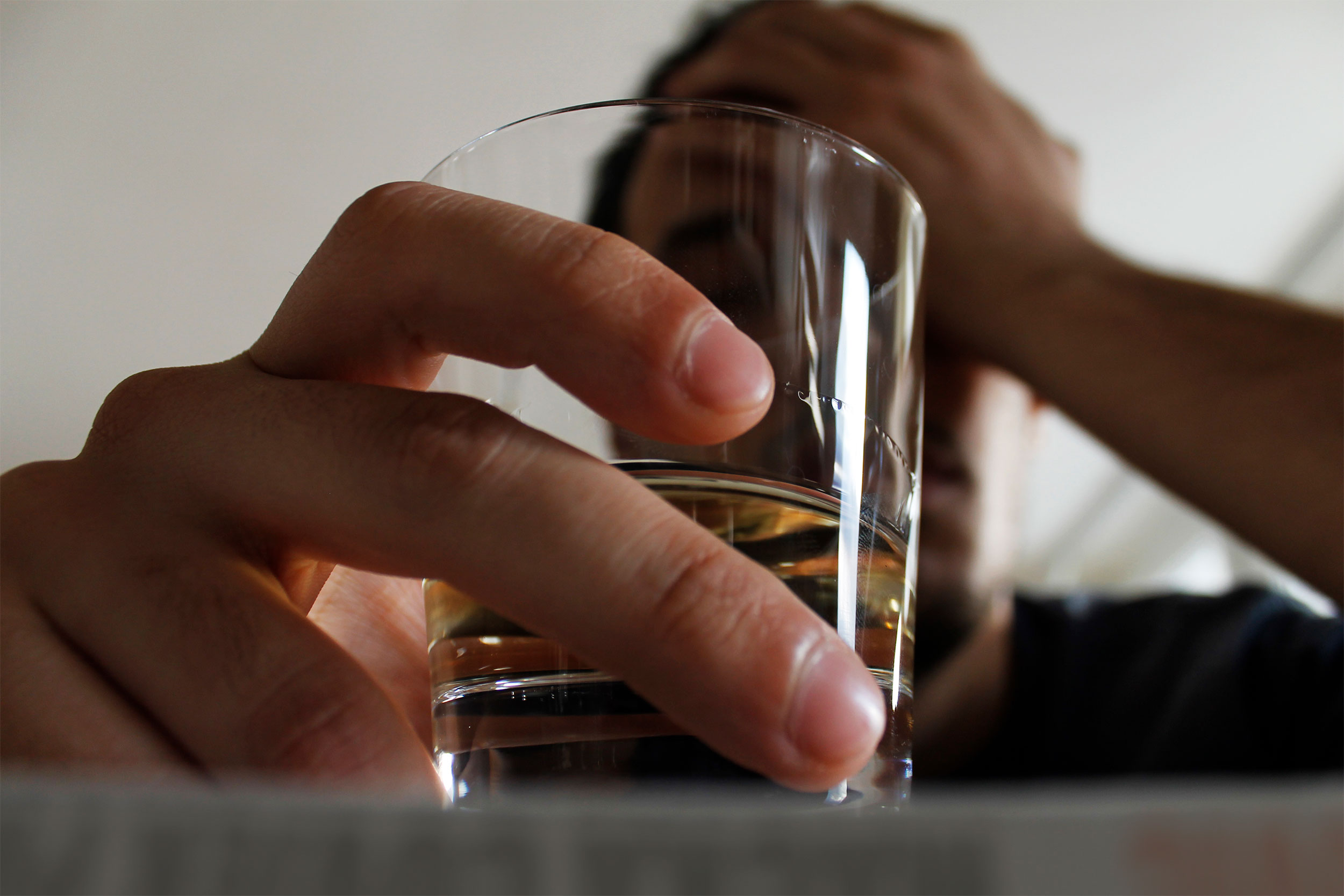 Man holding a glass of alcohol.