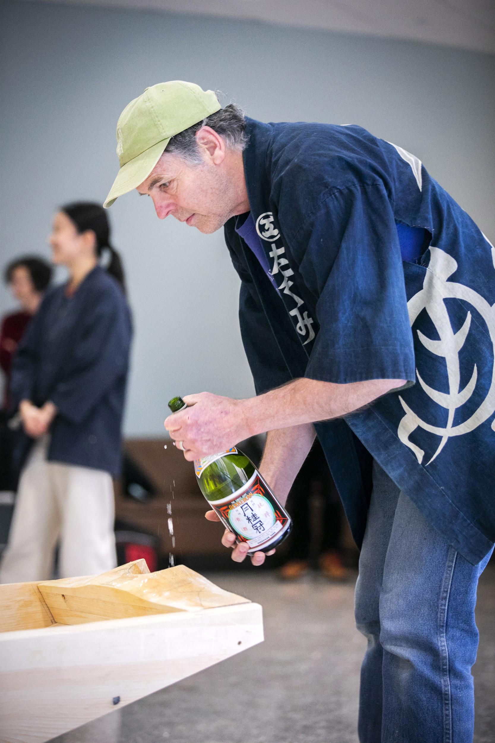 Brooks pours sake on the boat during the ritual ceremony at the end of the build.