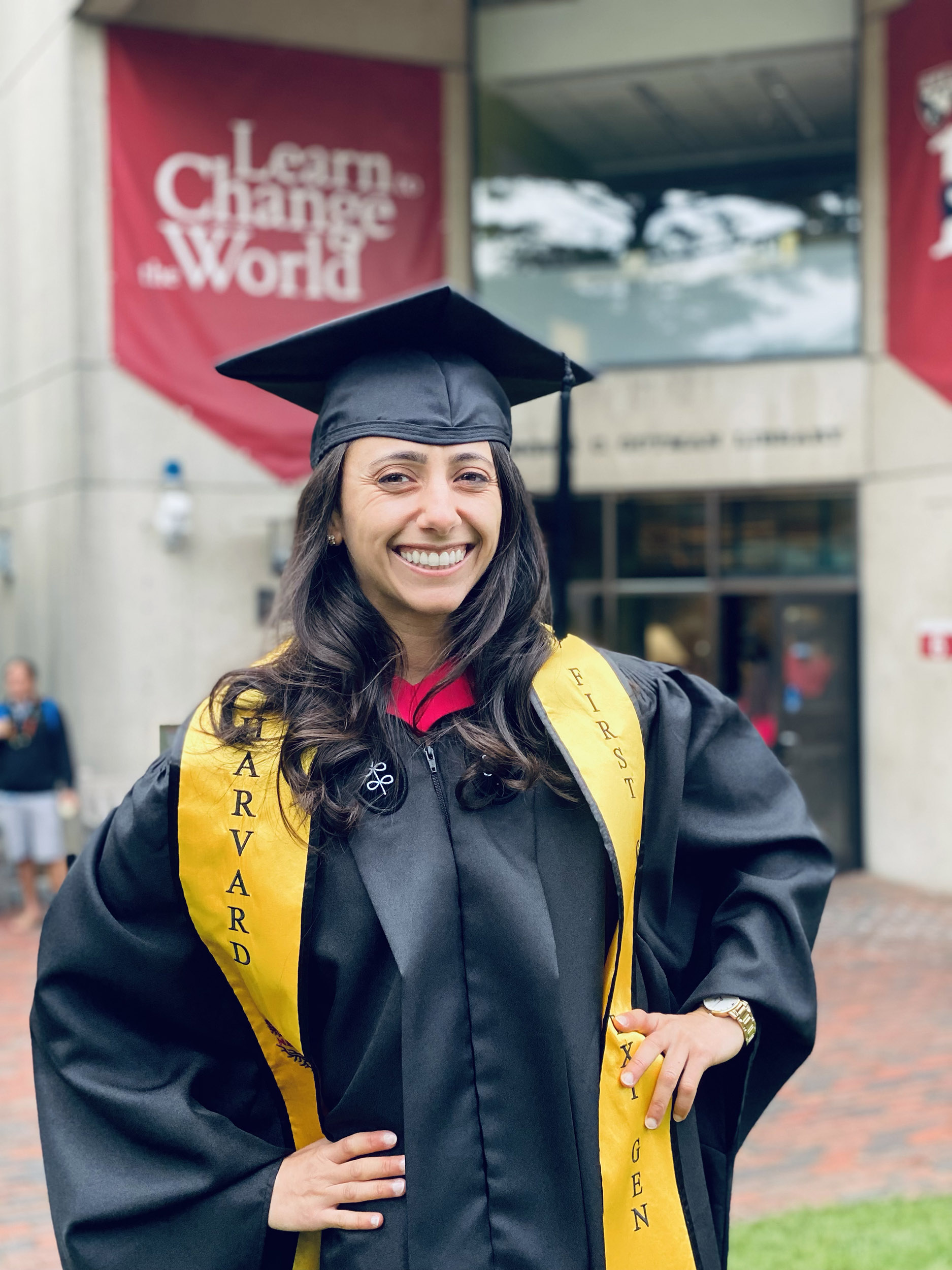 Alia Qatarneh in Commencement cap and gown outside Gutman Library.