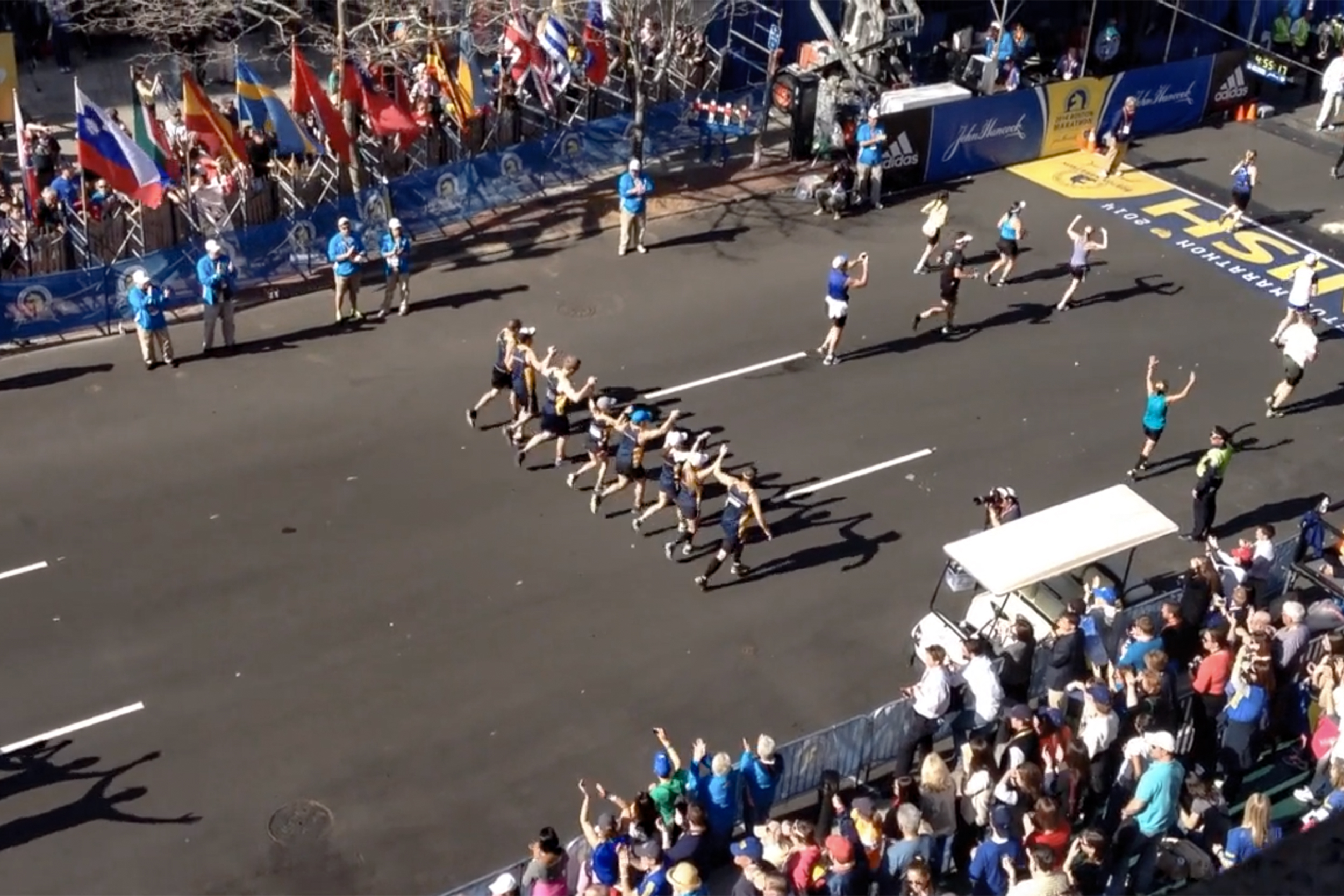 Eight members of Reny family hold hands crossing marathon finish line.