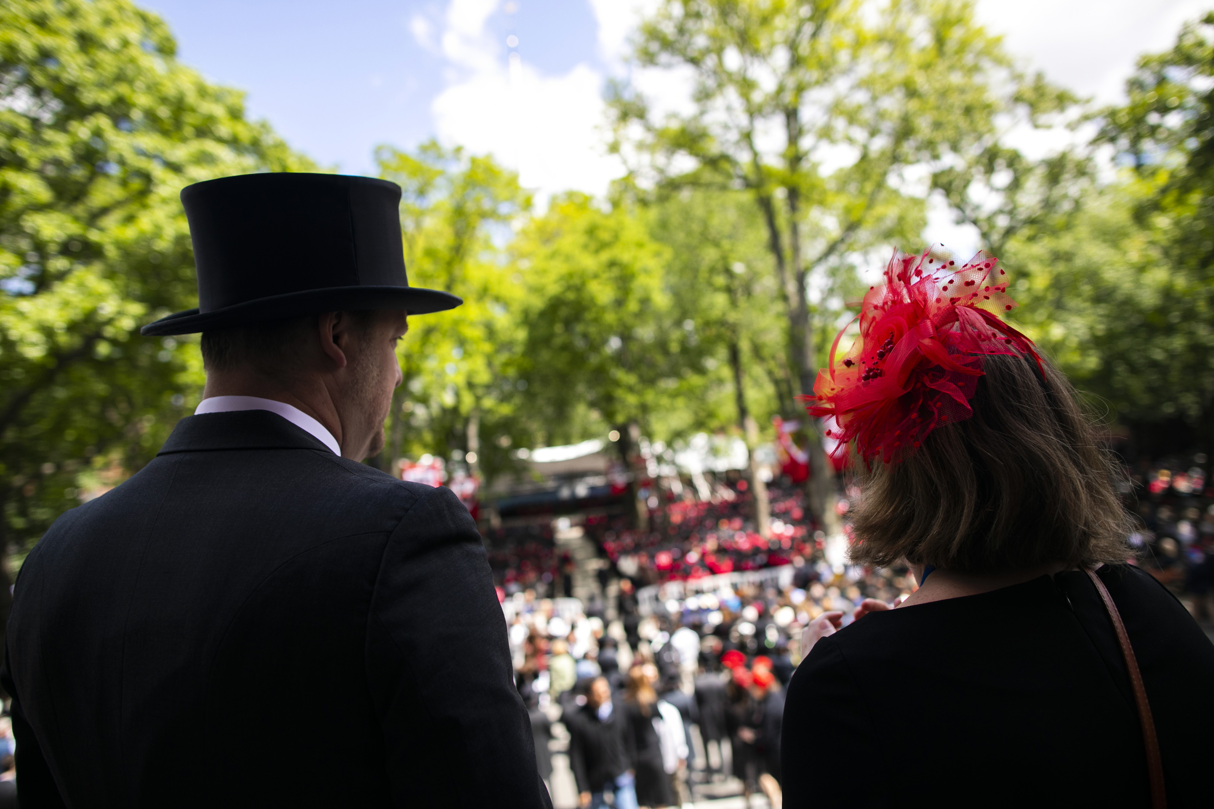 Nate Warren and Elizabeth Sapia silhouetted against Commencement backdrop in Harvard Yard.