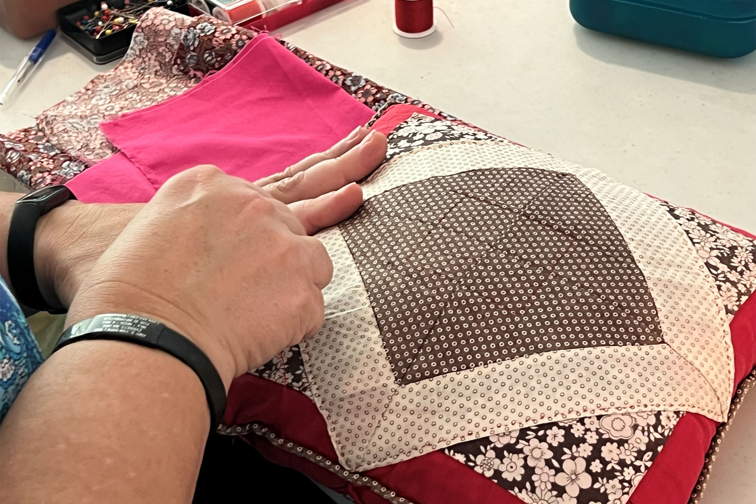 Closeup of Amy Van Epps at work fixing a ripped pillow.