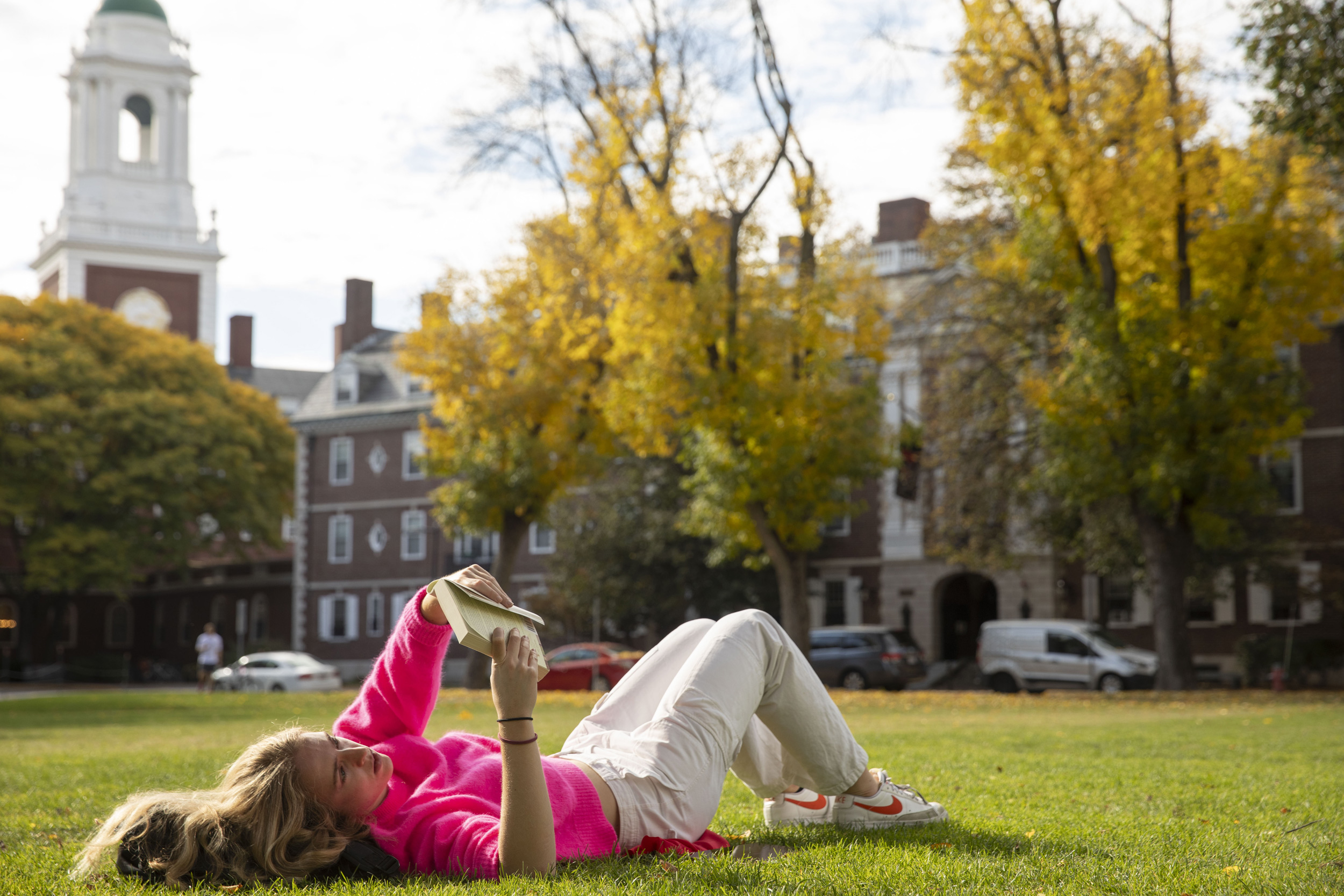 Corinne Furey ’25 lies on the MAC Quadrangle while reading a book.