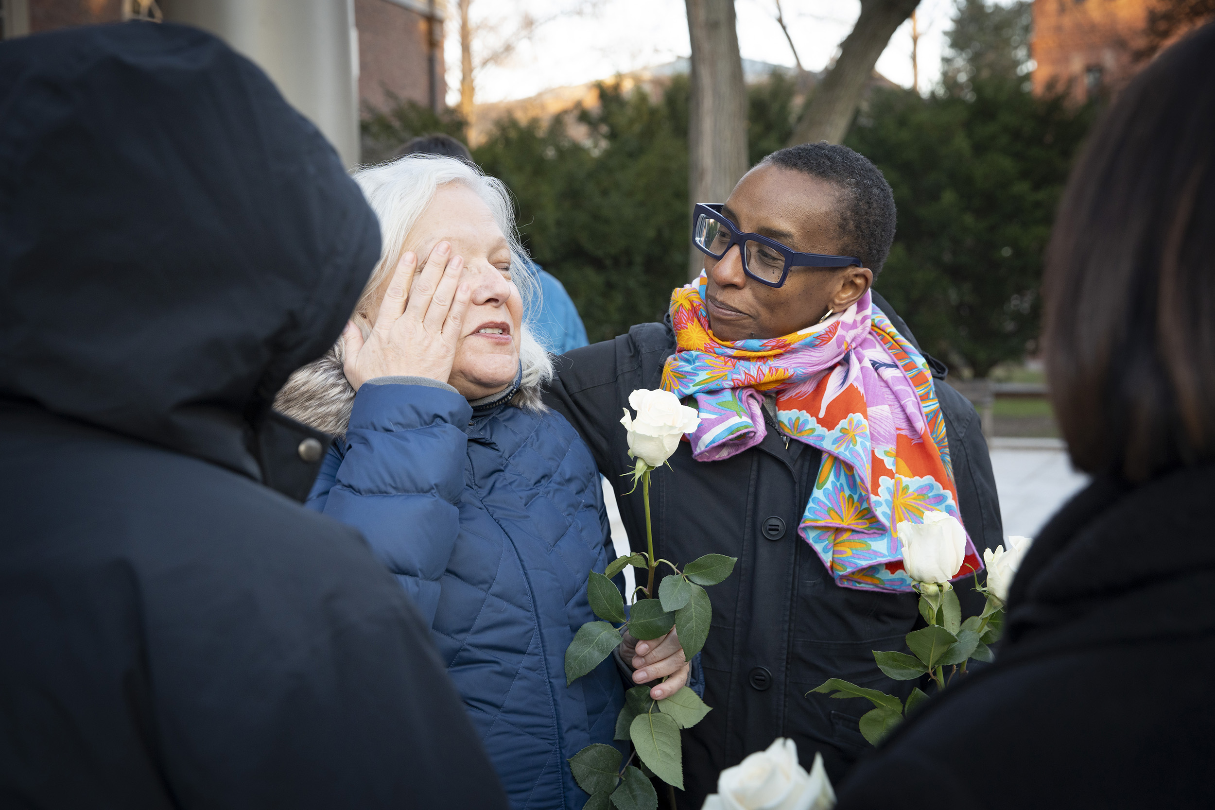 Claudine Gay comforts a woman as she wipes a tear.