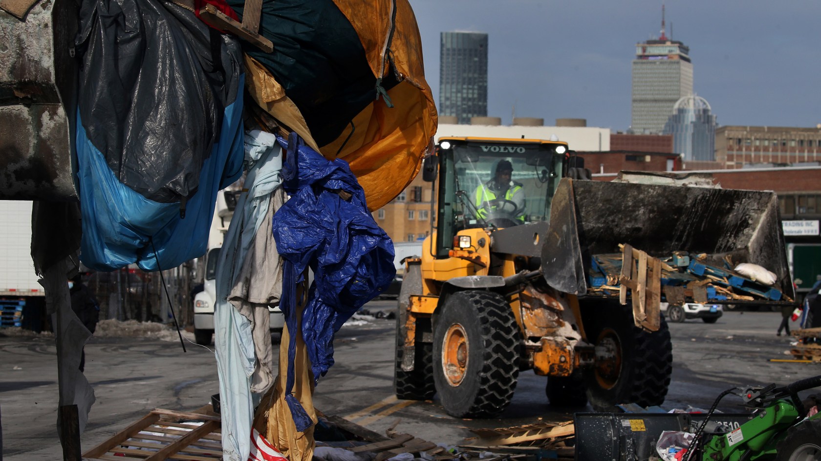 Front-end loaders take down tents and debris.