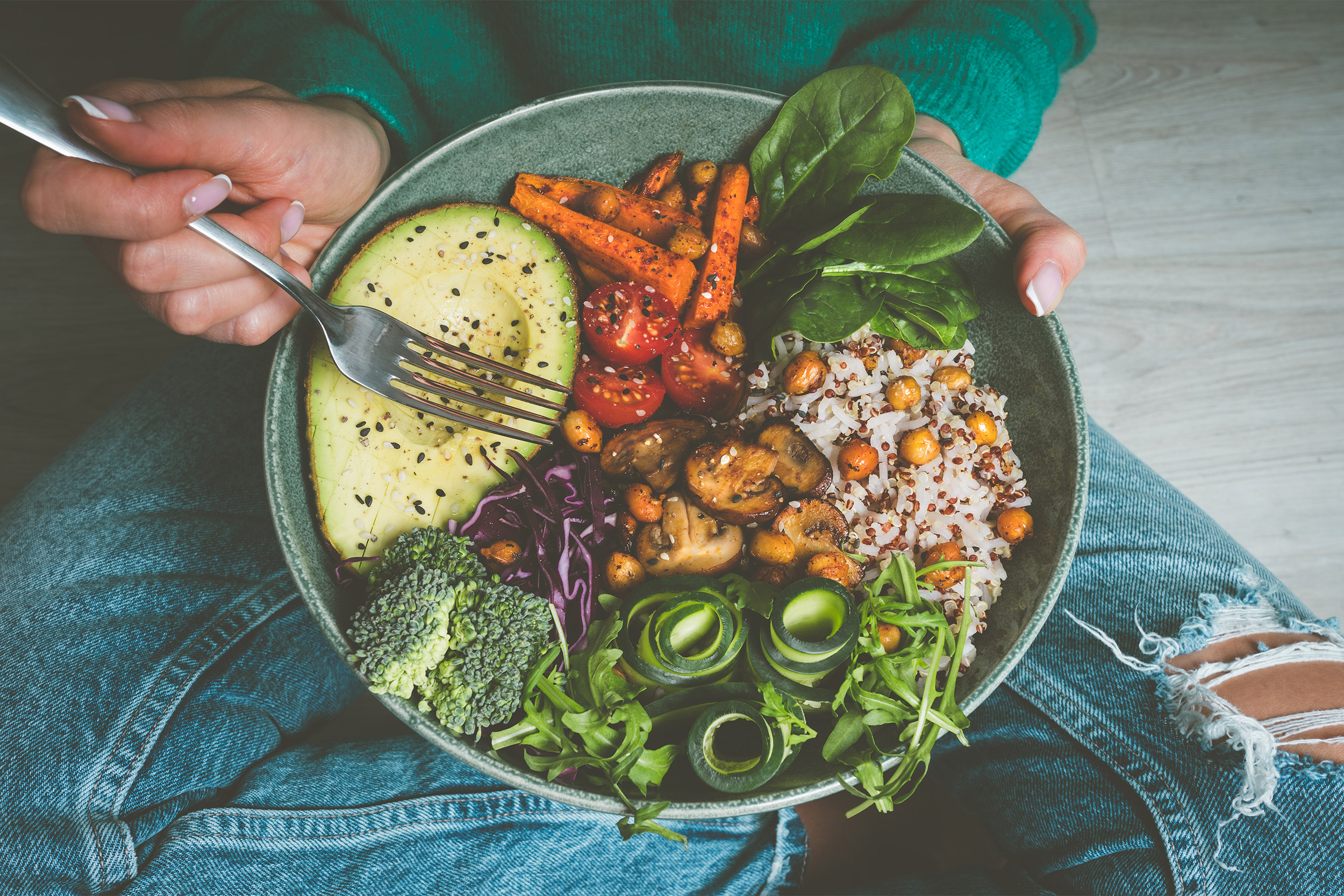 Woman with a bowl of plant-based food.