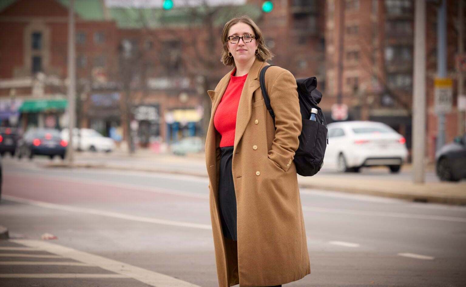 Jen Cruz standing with her backpack on the street. 