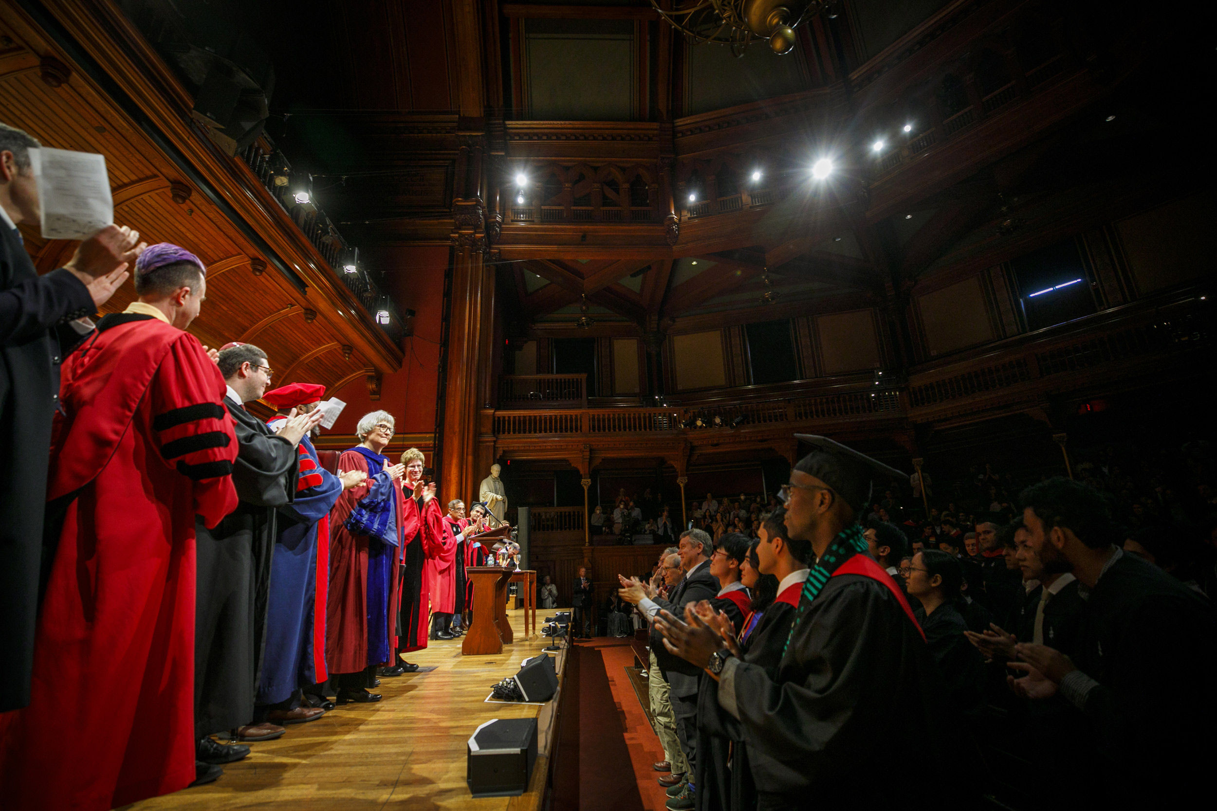 President Emerita Drew Faust (center) acknowledges the audience after receiving a standing ovation for her oration. 